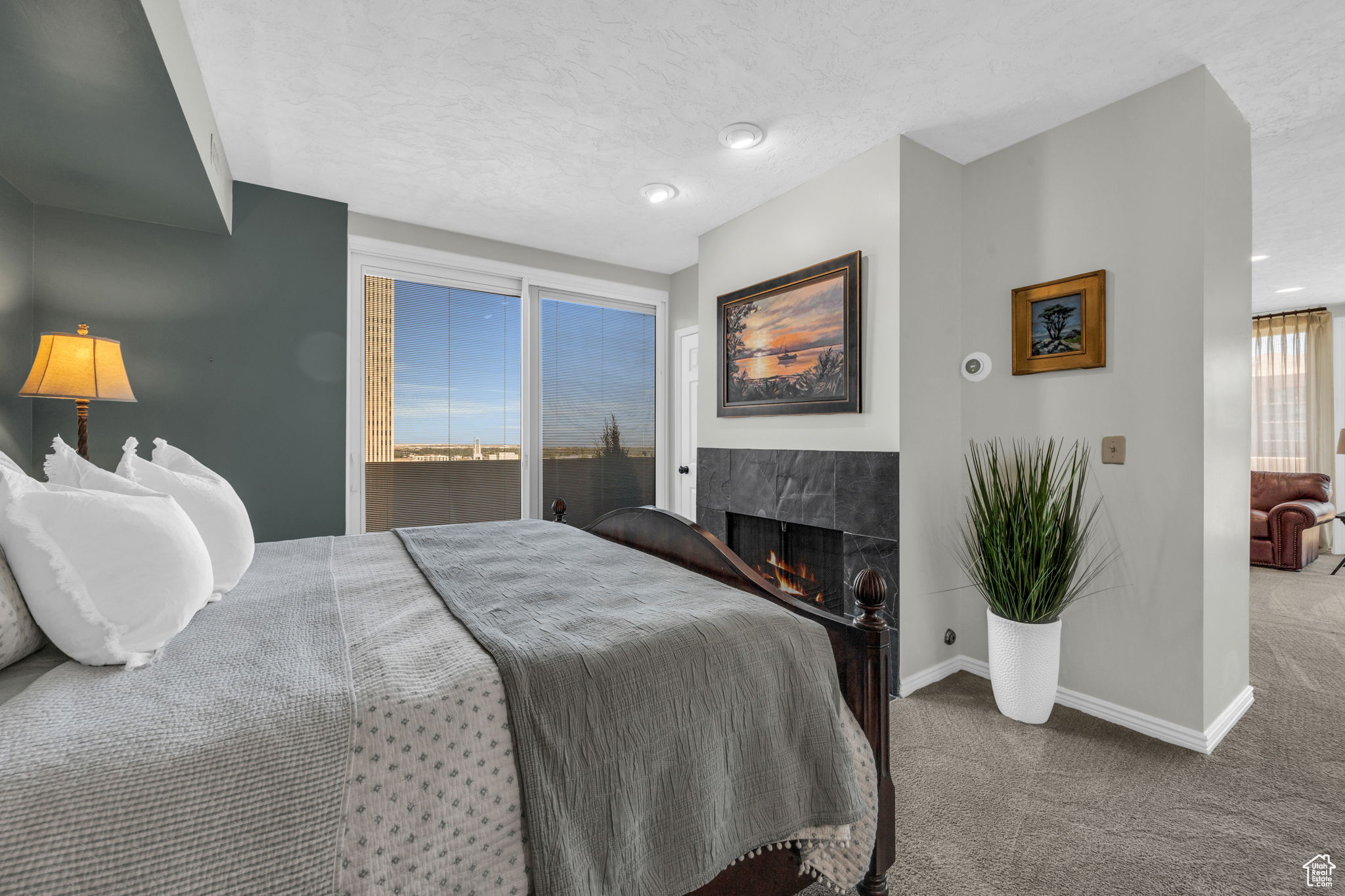 Bedroom with on-suite bathroom , carpet flooring, a fireplace, floor-to-ceiling windows, and access to an exterior balcony overlooking downtown and the west sunset