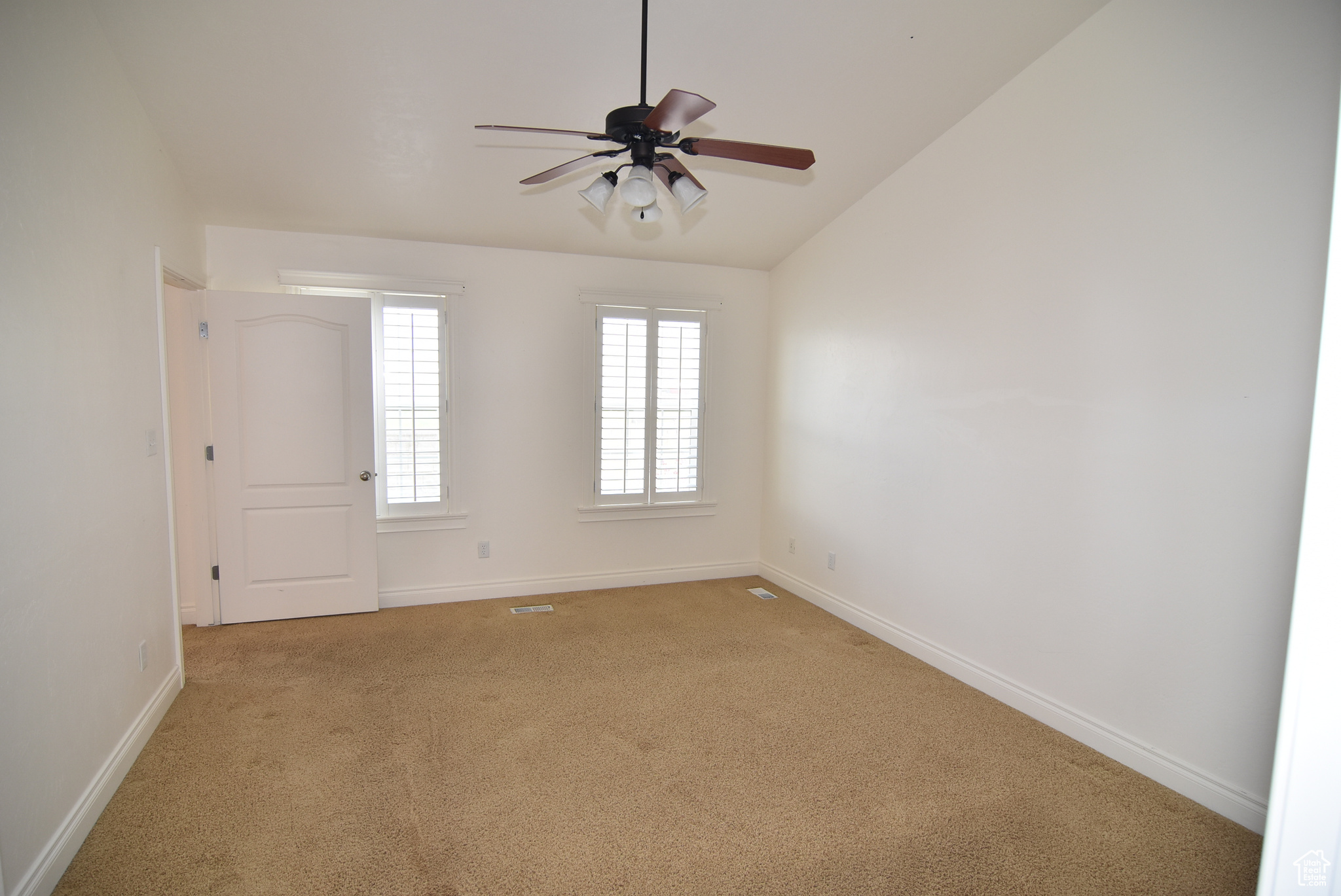 Master suite with ceiling fan, vaulted ceilings and plantation shutters