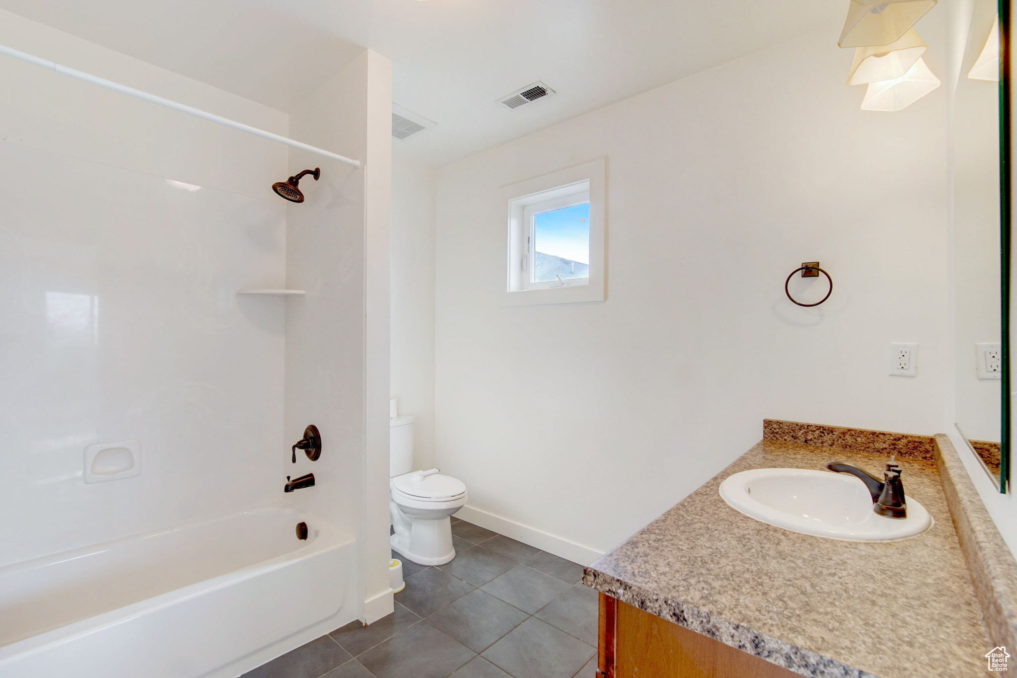 Full bathroom with tub / shower combination, toilet, tile flooring, and vanity