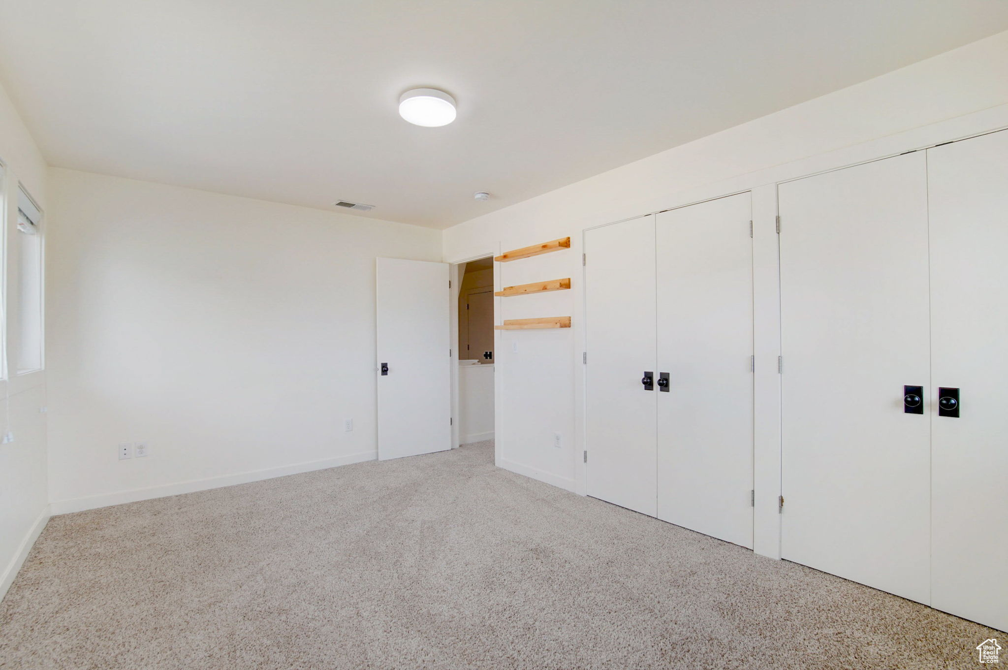 Unfurnished bedroom featuring multiple closets and carpet
