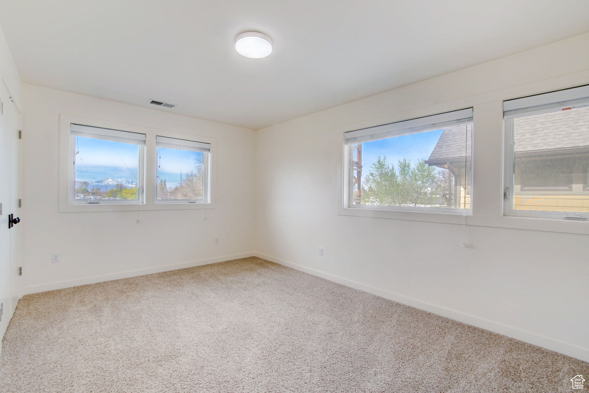 Empty room with a healthy amount of sunlight and carpet flooring