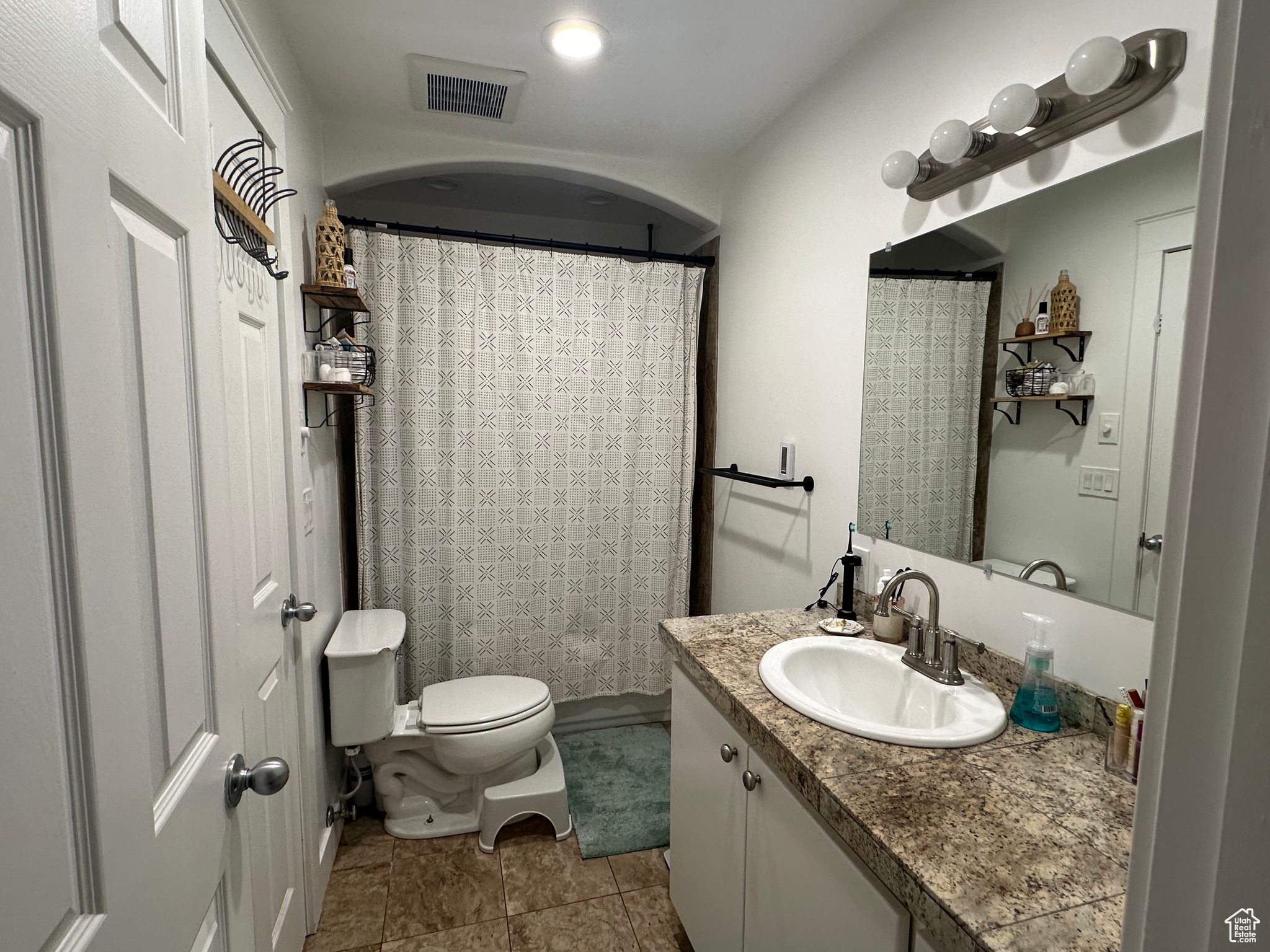 Bathroom featuring toilet, tile floors, and large vanity
