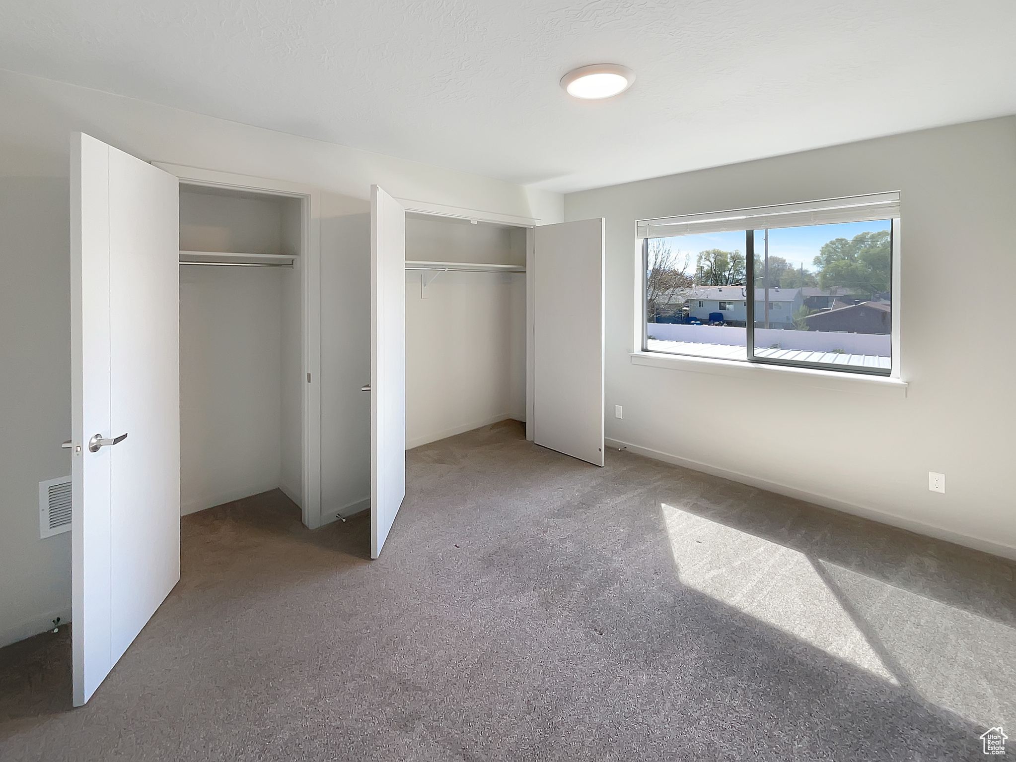 Unfurnished bedroom featuring two closets and carpet floors