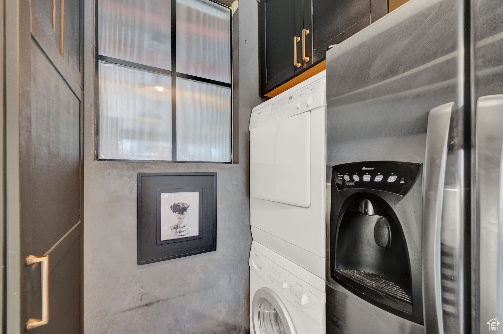 Washroom with cabinets and stacked washer / drying machine