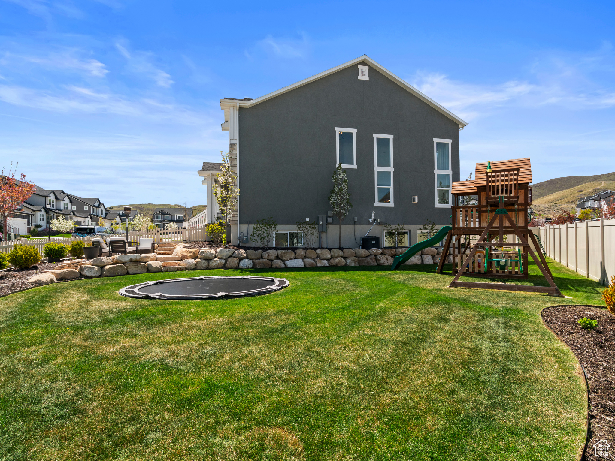 Front and side yard are home to the in ground trampoline and play structure.