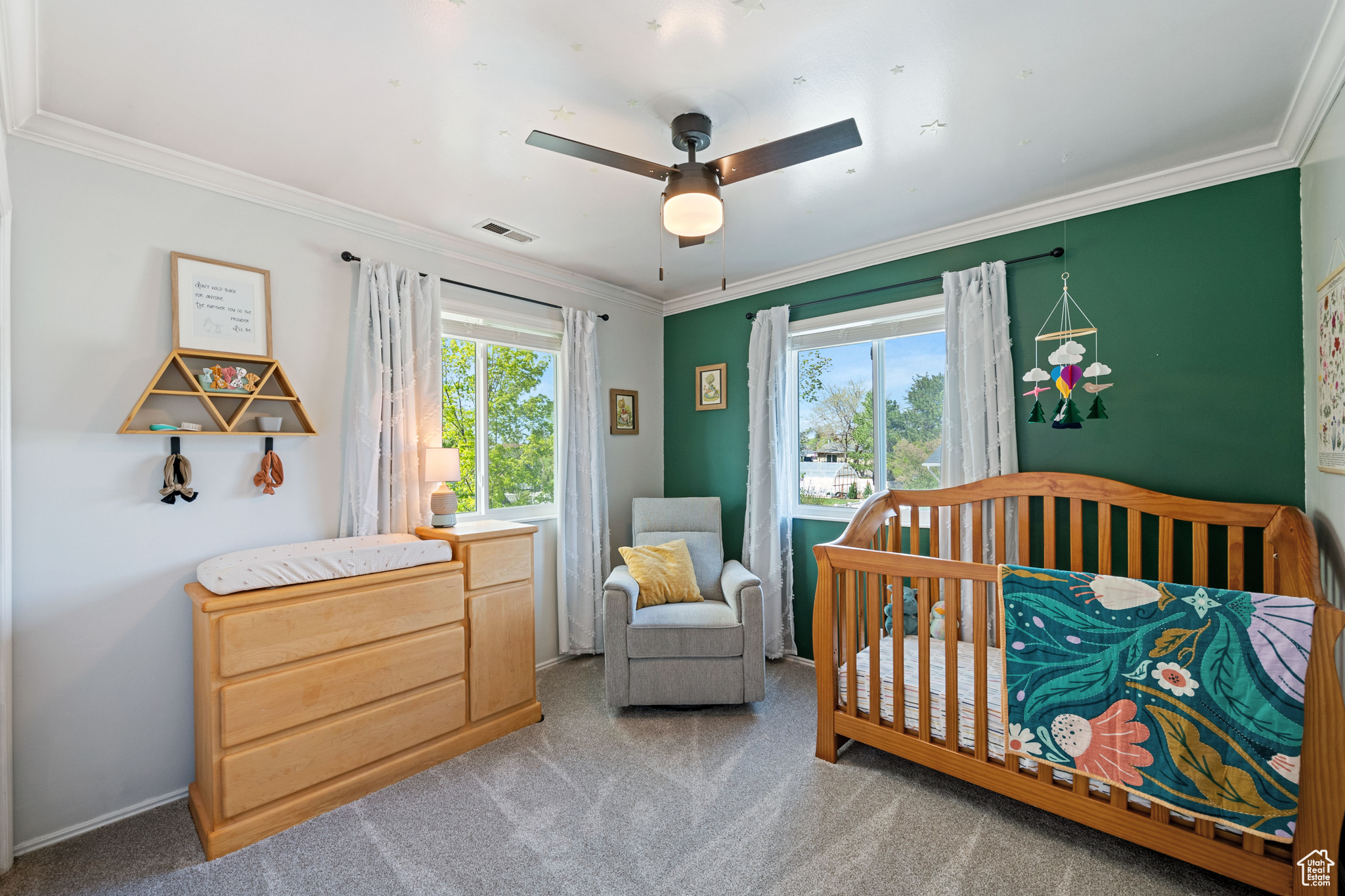 Bedroom featuring crown molding, ceiling fan, a crib, and carpet floors