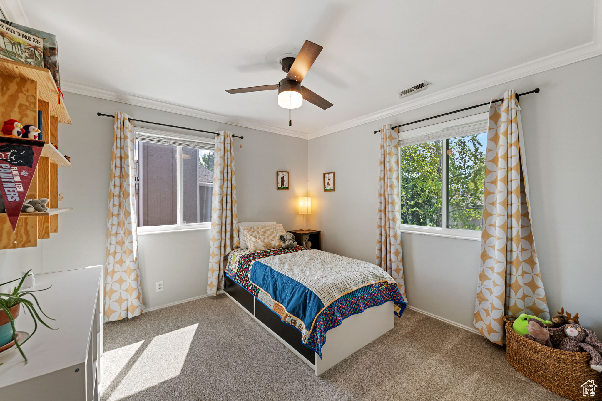 Carpeted bedroom featuring ceiling fan and crown molding