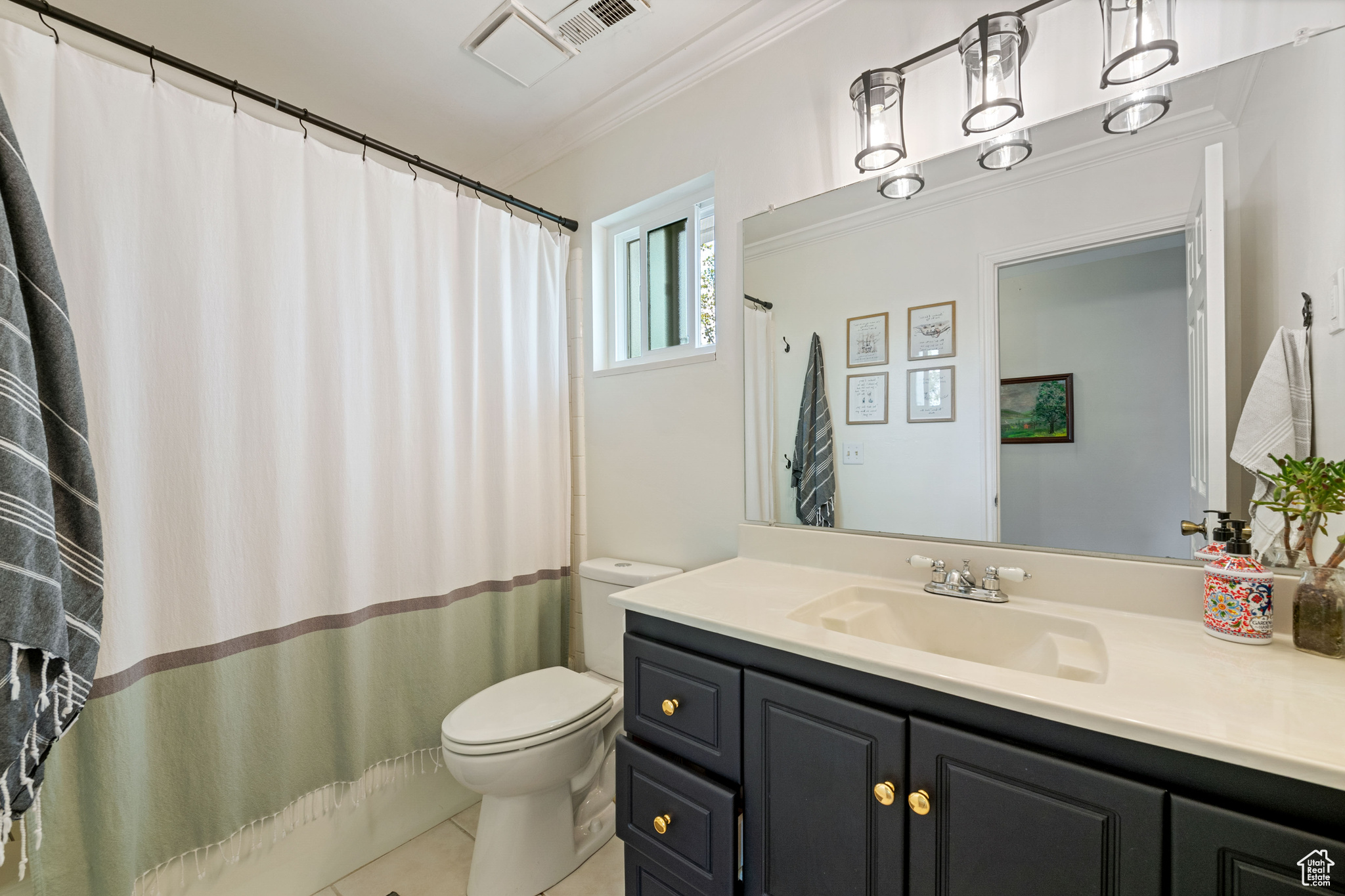 Bathroom with crown molding, toilet, tile floors, and large vanity