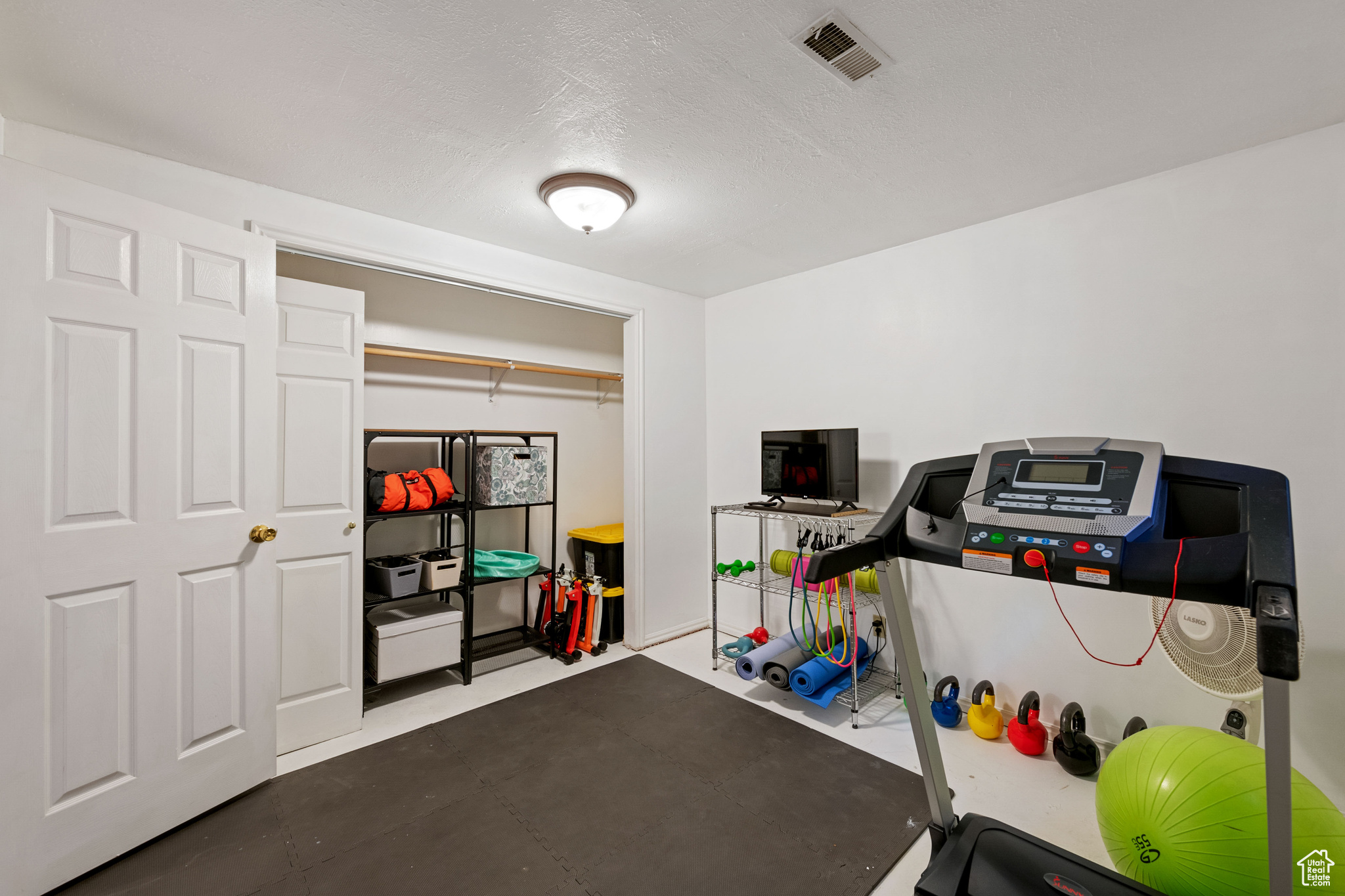Workout area featuring a textured ceiling and concrete floors
