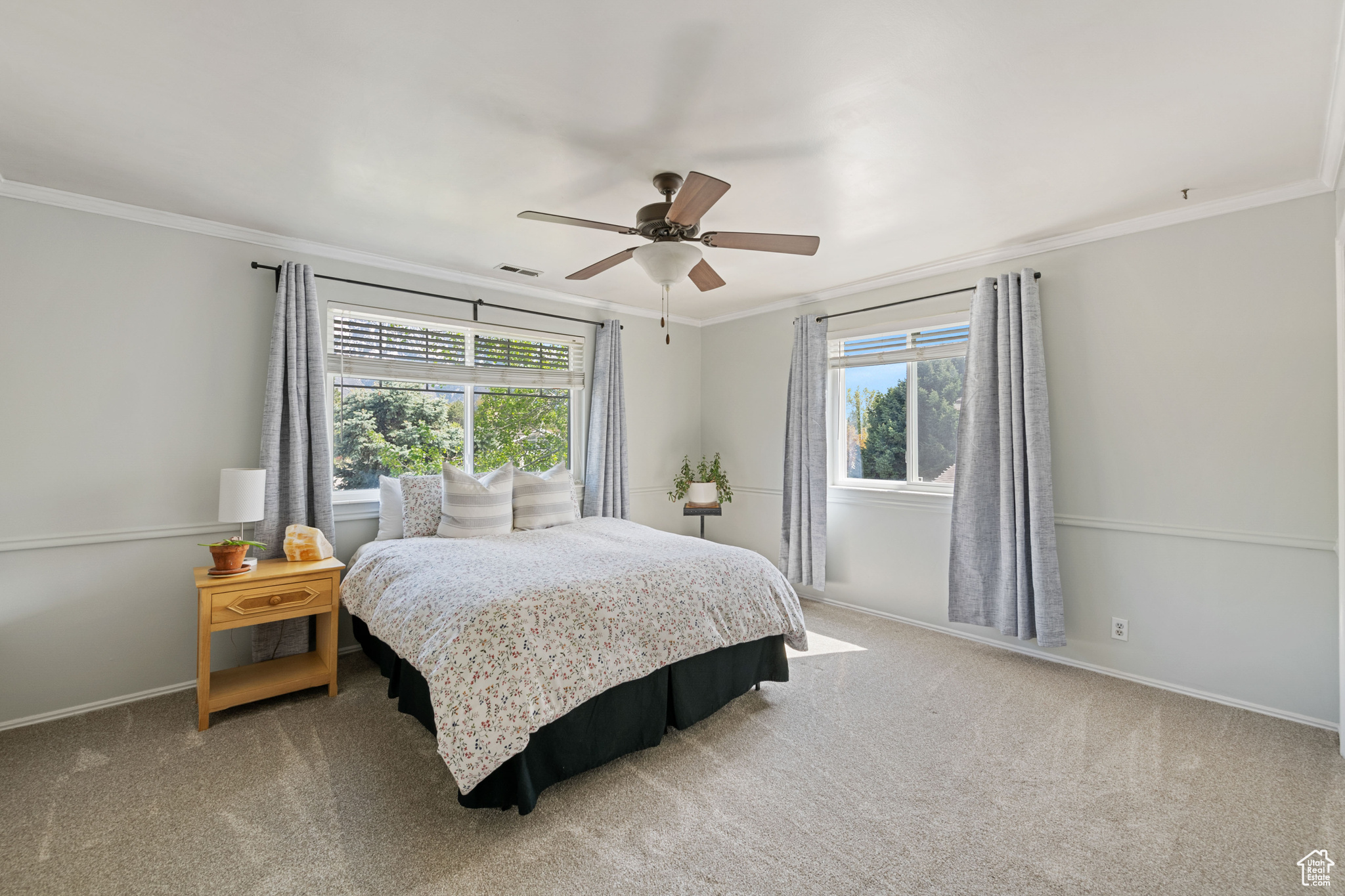 Bedroom with carpet flooring, ceiling fan, and ornamental molding