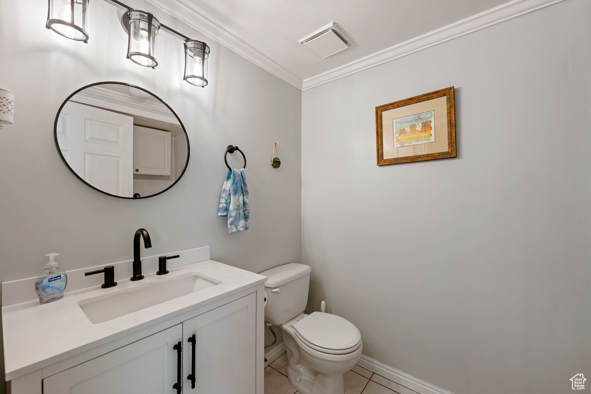 Bathroom featuring tile floors, crown molding, toilet, and large vanity