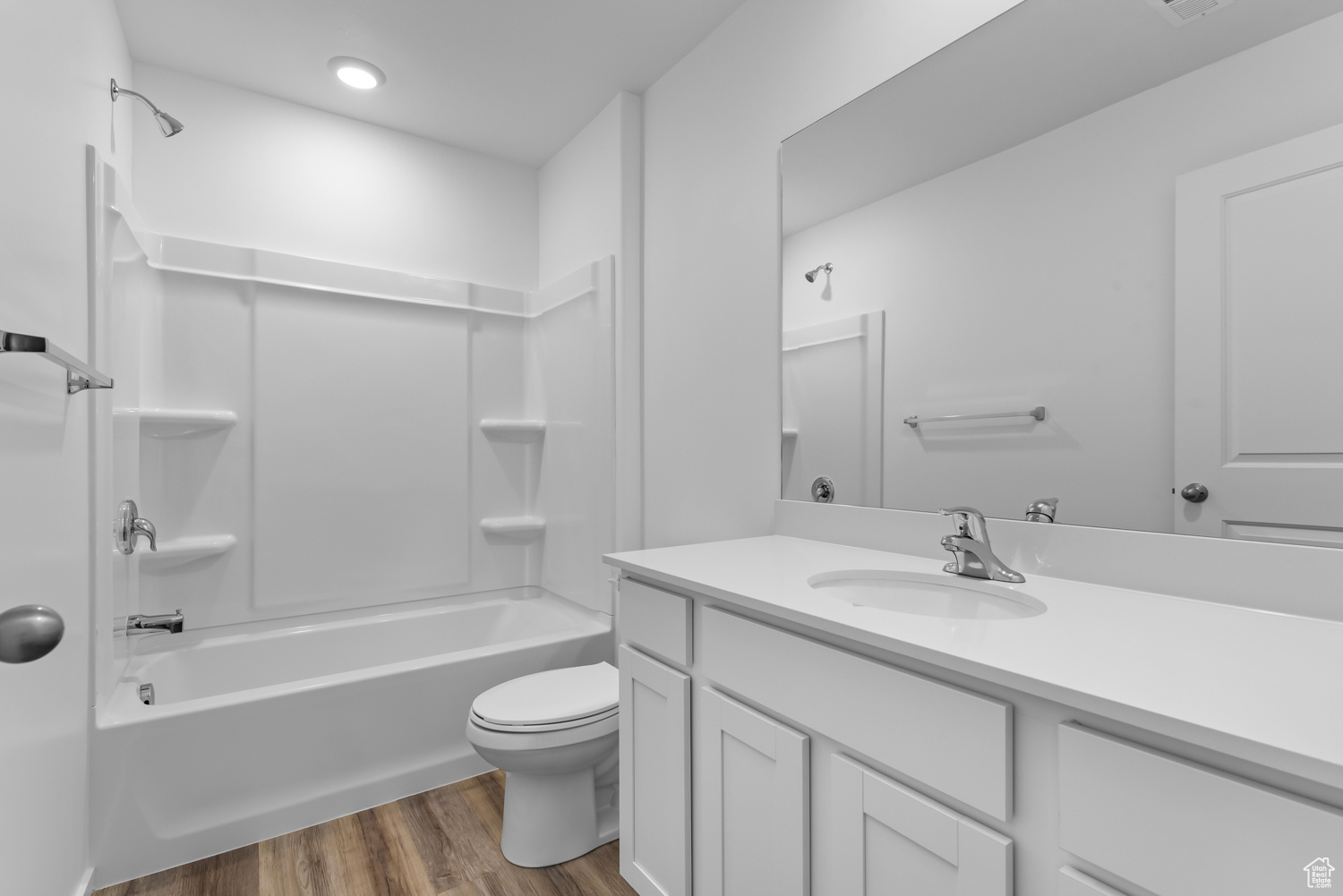 Full bathroom featuring wood-type flooring, vanity, toilet, and shower / washtub combination