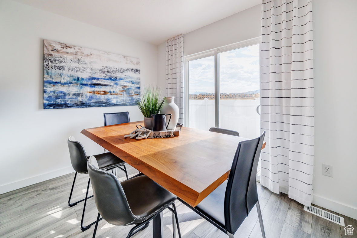 Dining area featuring hardwood / wood-style floors and a water view