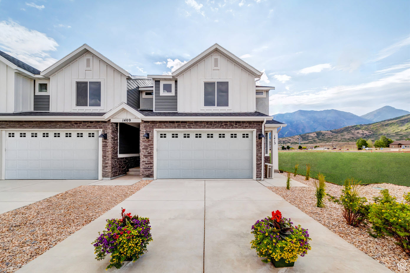 View of front of property with a garage and a mountain view