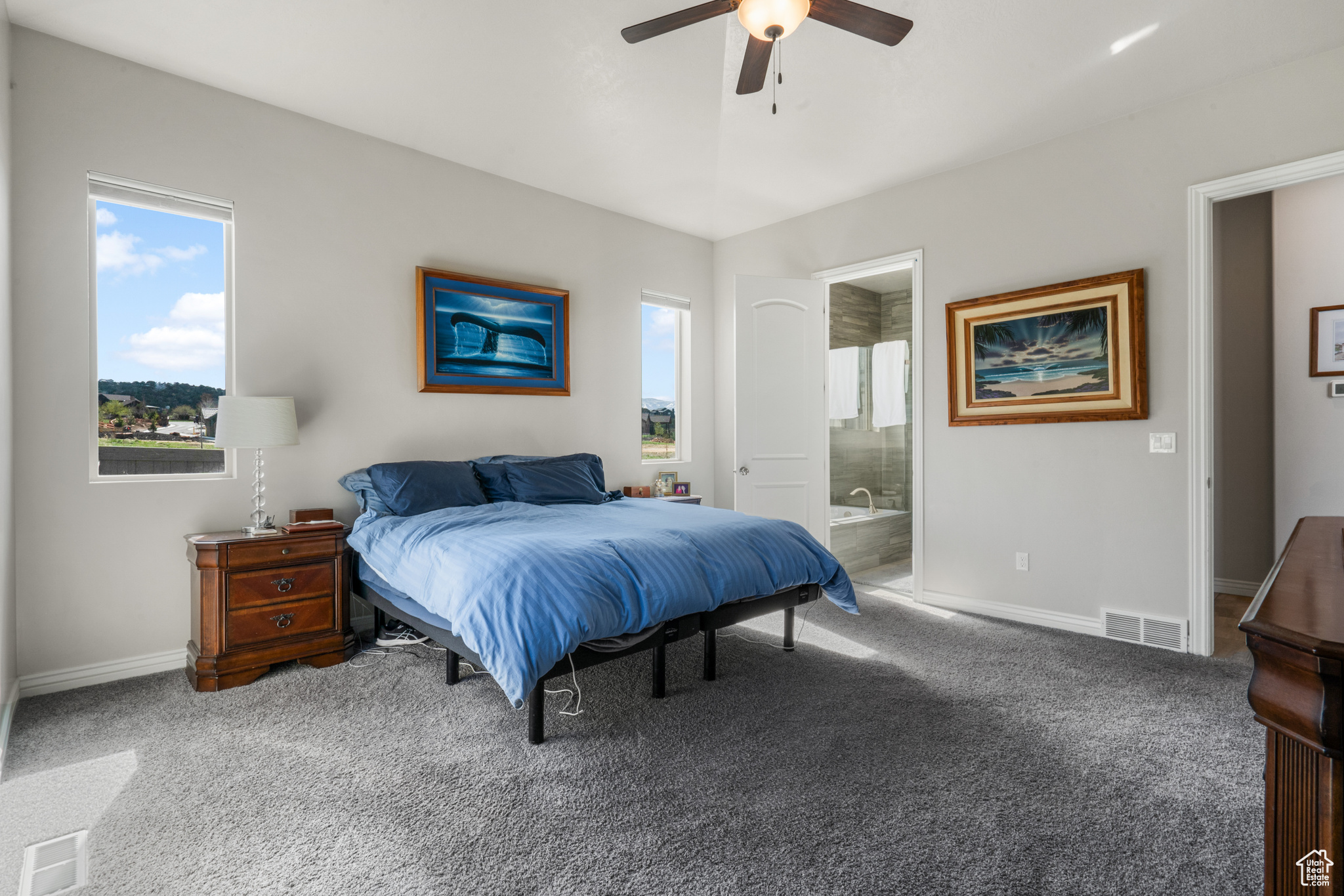 Bedroom with ceiling fan, carpet floors, and ensuite bathroom