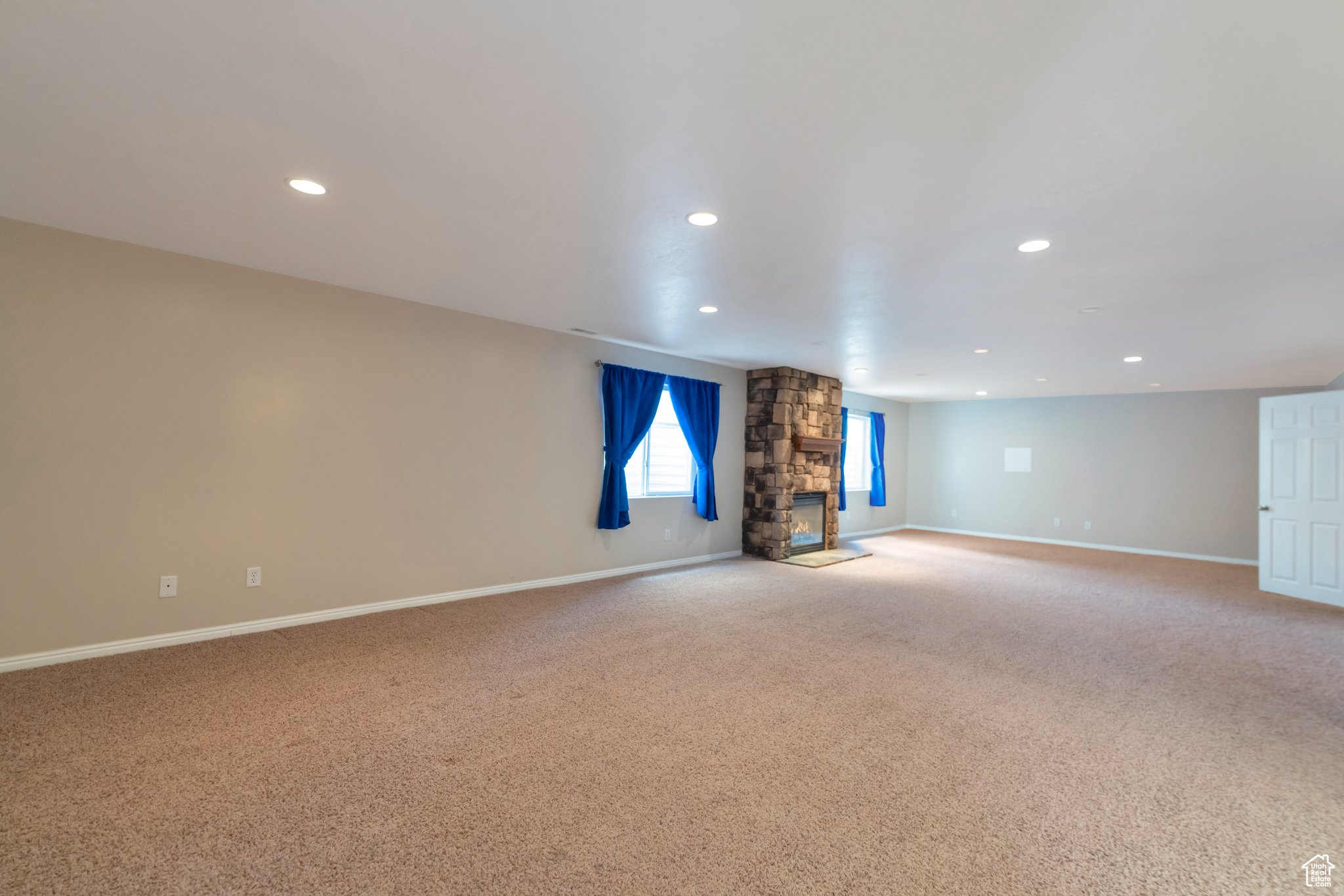 Basement Family room featuring a stone fireplace