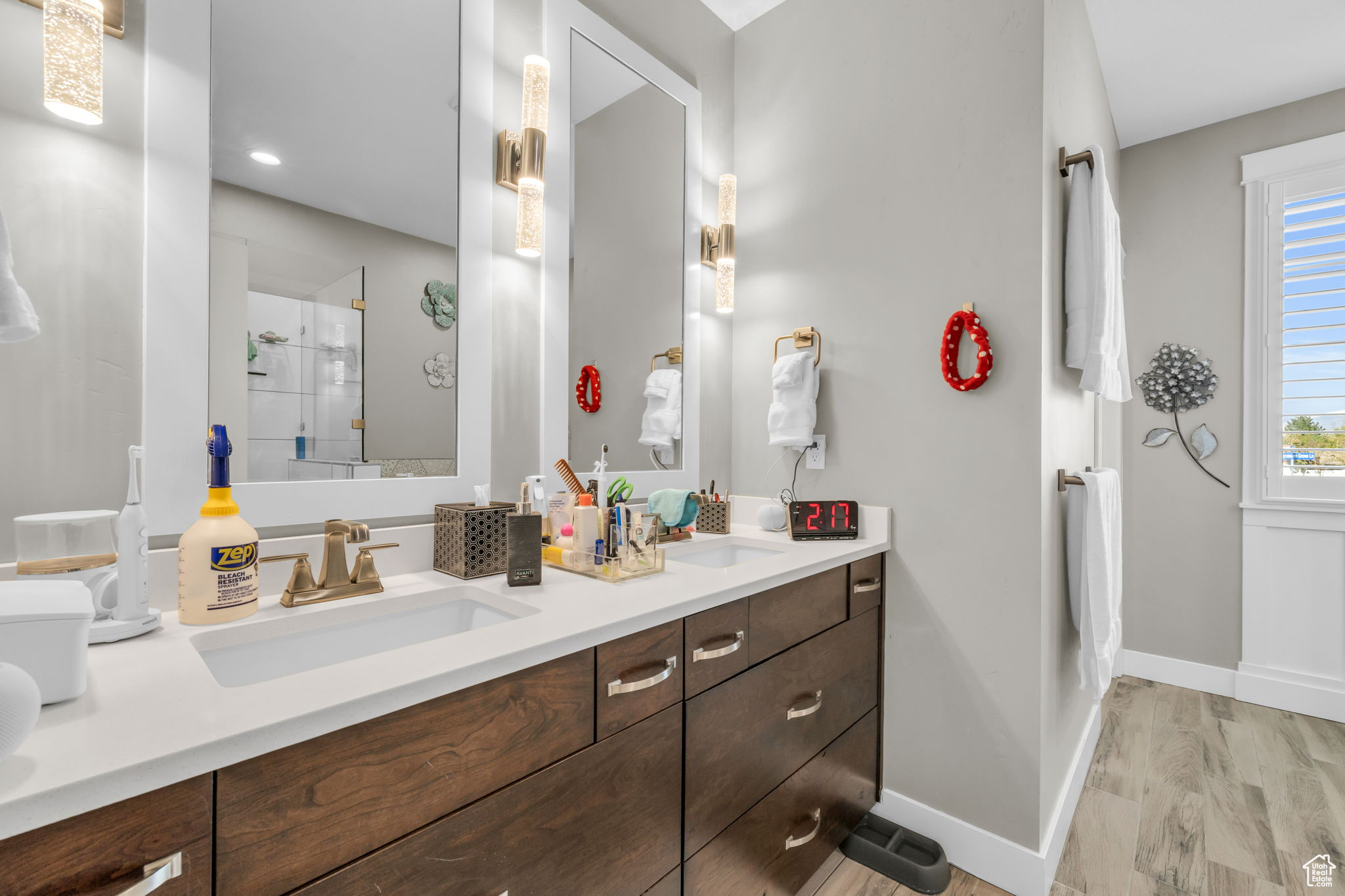 Bathroom featuring hardwood / wood-style floors, double sink vanity, and a shower