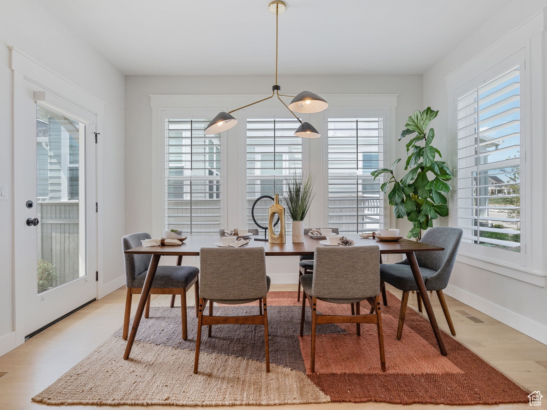 Dining space with plenty of natural light, white oak hardwood flooring, and contemporary light fixtures.