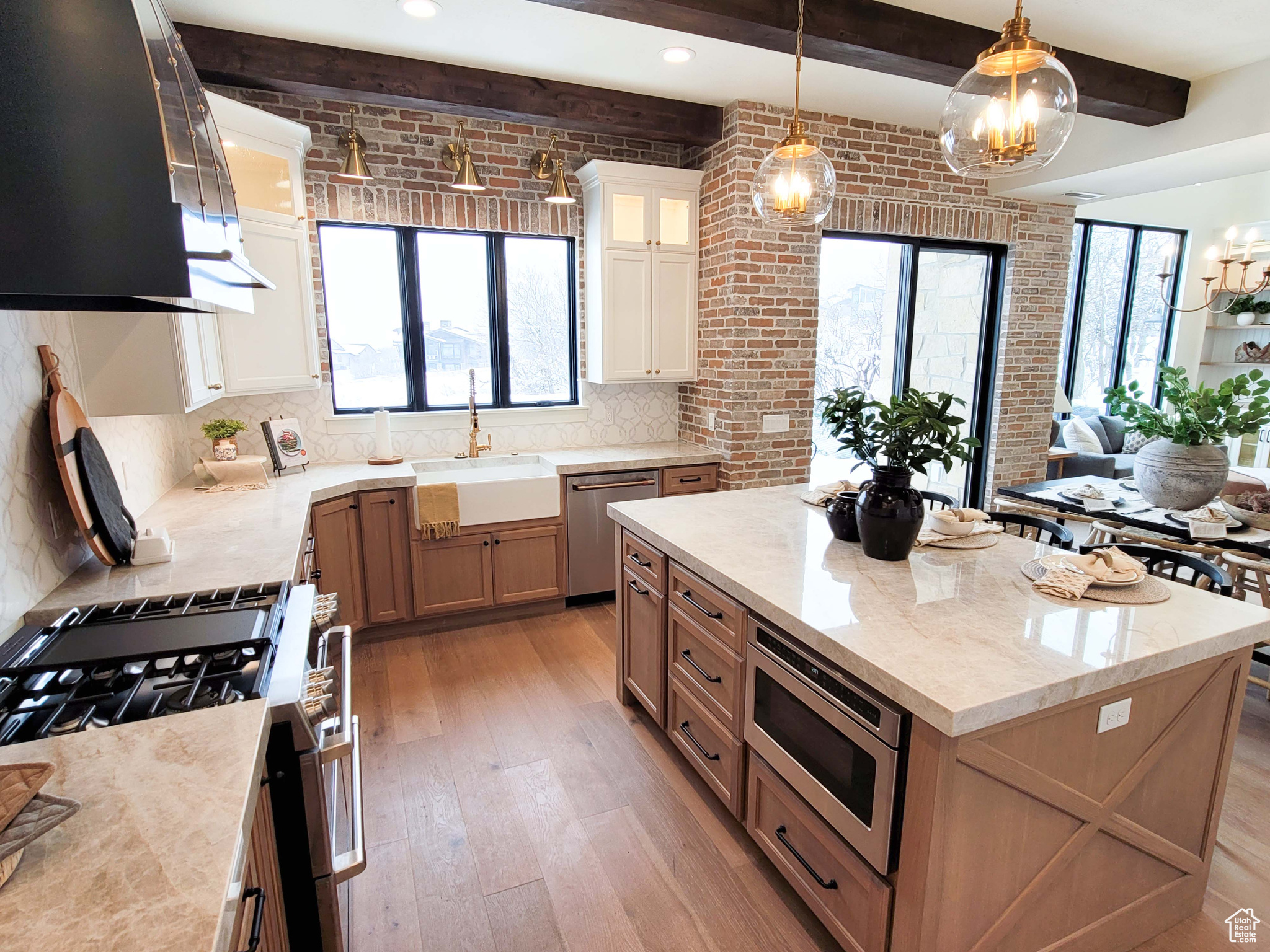 Kitchen with appliances with stainless steel finishes, a center island, sink, backsplash, and light wood-type flooring