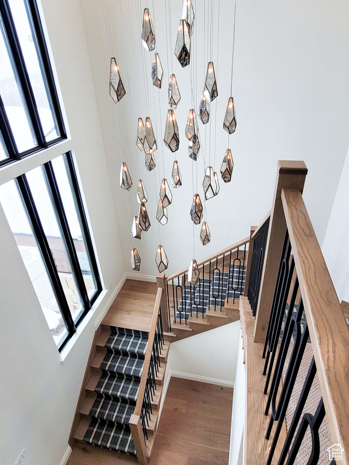 Staircase featuring wood-type flooring and a towering ceiling