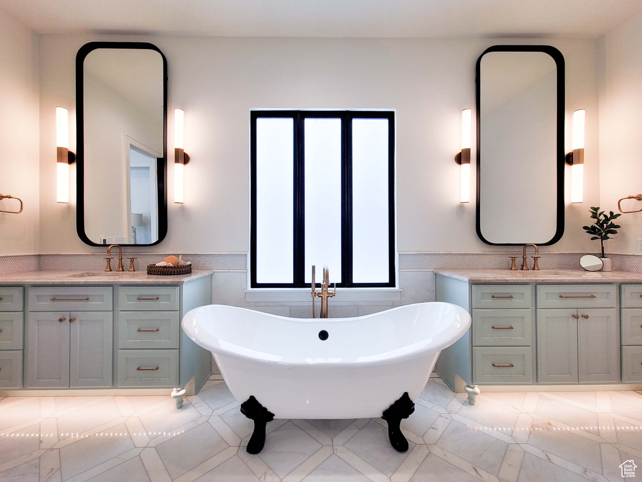 Bathroom featuring tile floors, dual vanity, and a washtub
