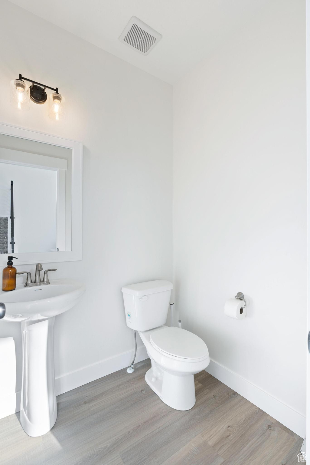 Bathroom with wood-type flooring and toilet