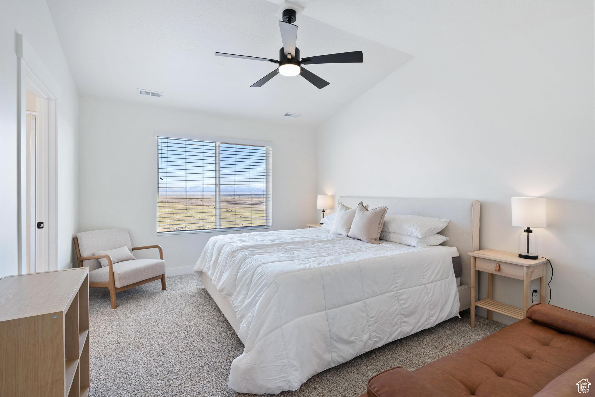 Carpeted bedroom featuring lofted ceiling and ceiling fan