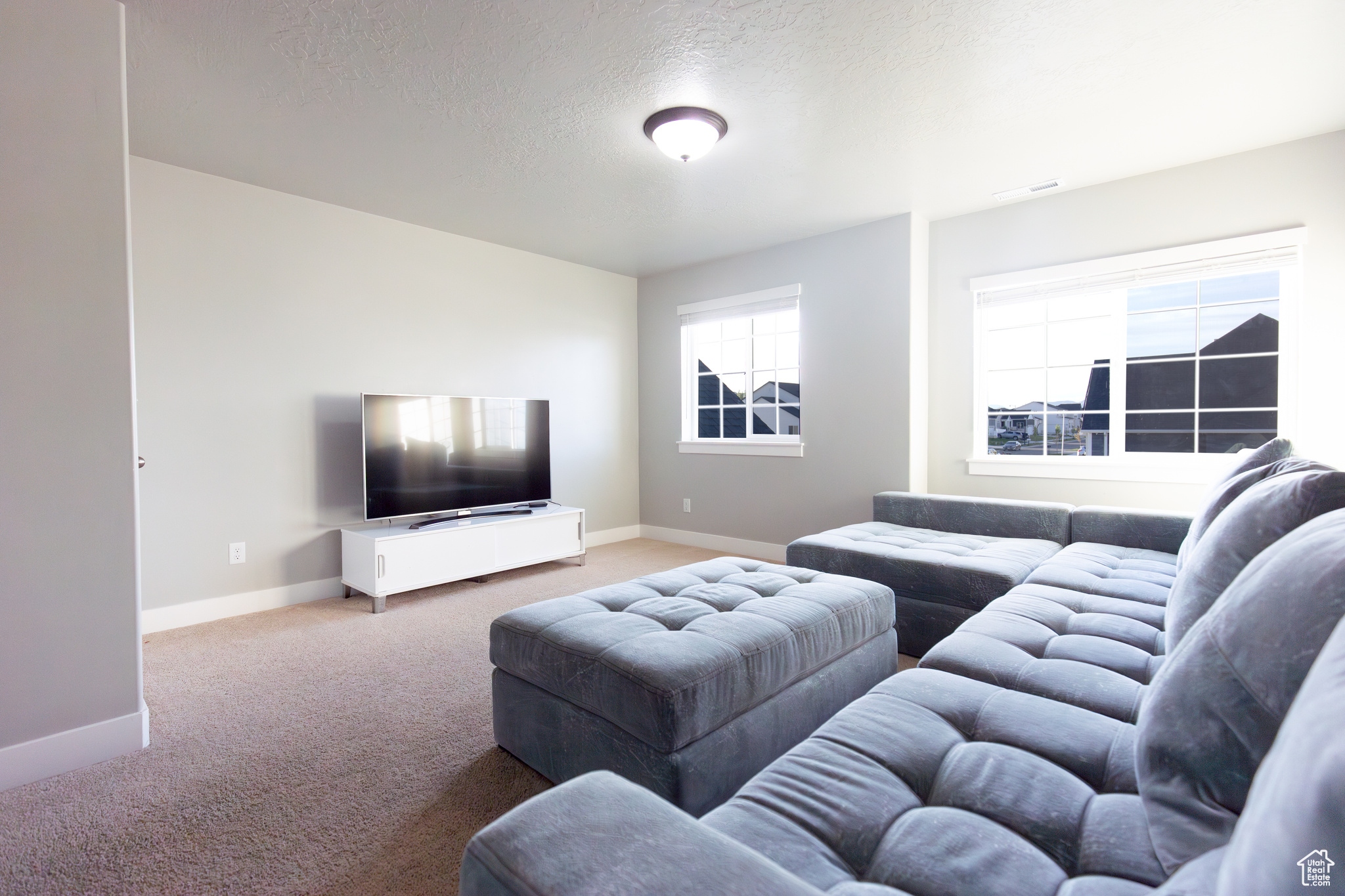 Carpeted living room with a textured ceiling