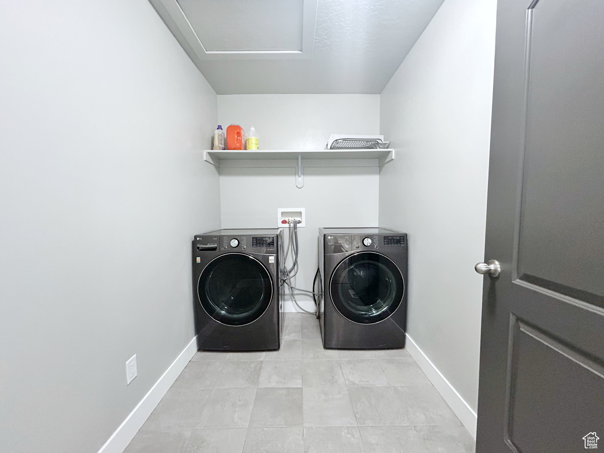 Washroom featuring washing machine and dryer, light tile floors, and washer hookup