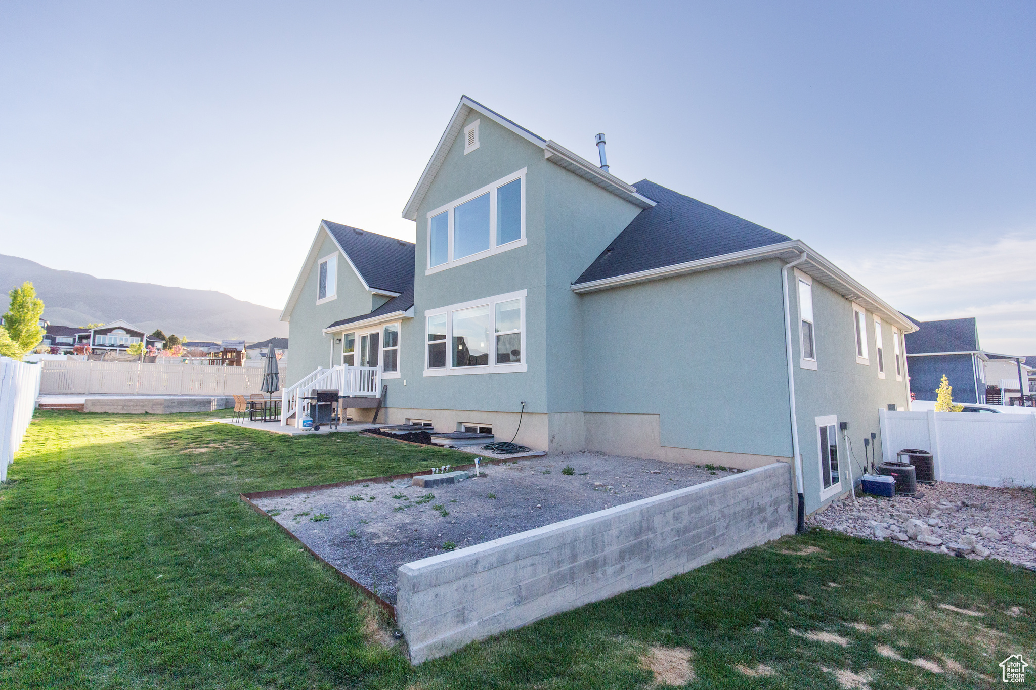 Rear view of house with a patio area, central AC, and a lawn