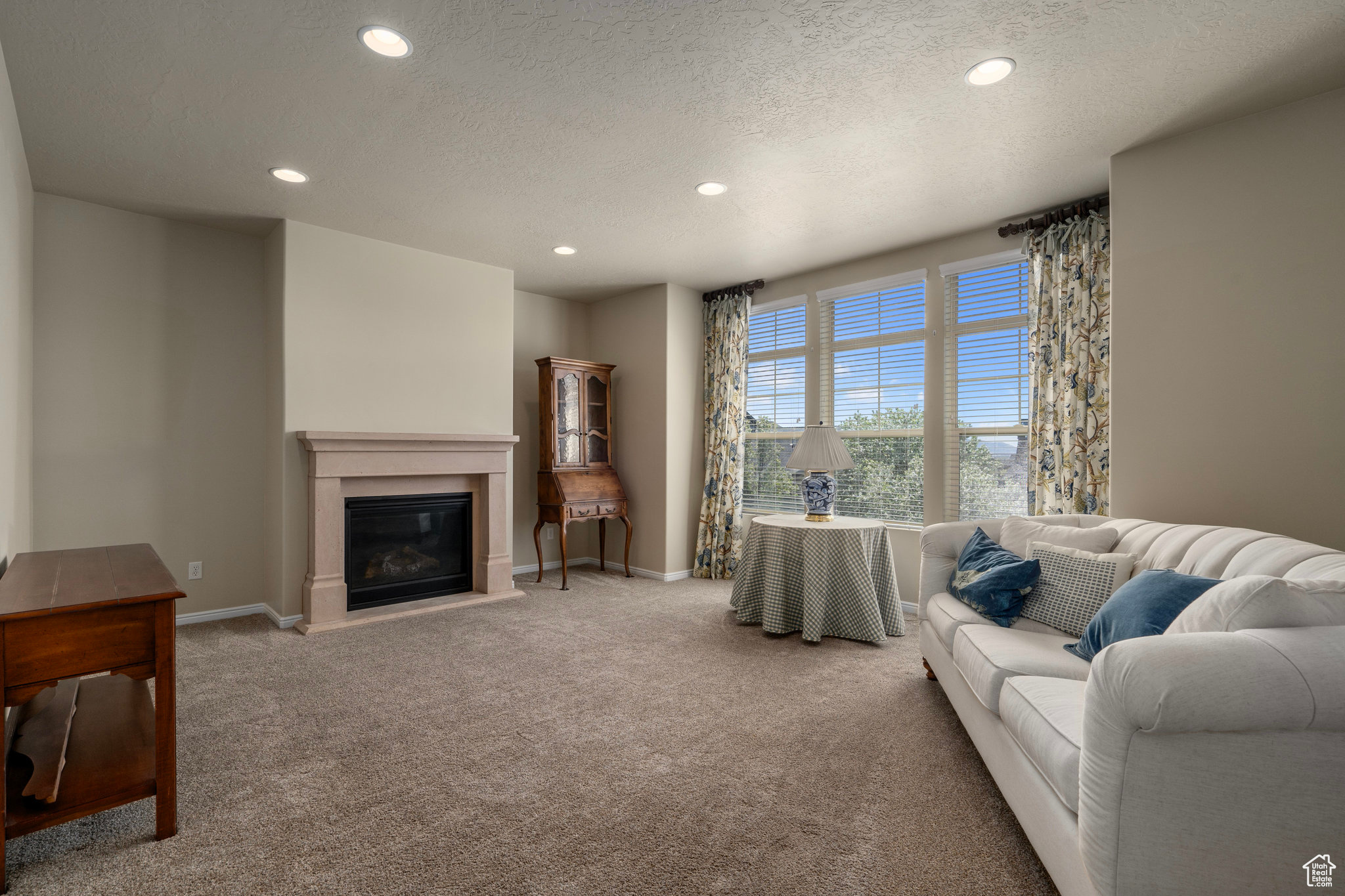 Living room featuring a textured ceiling and carpet flooring