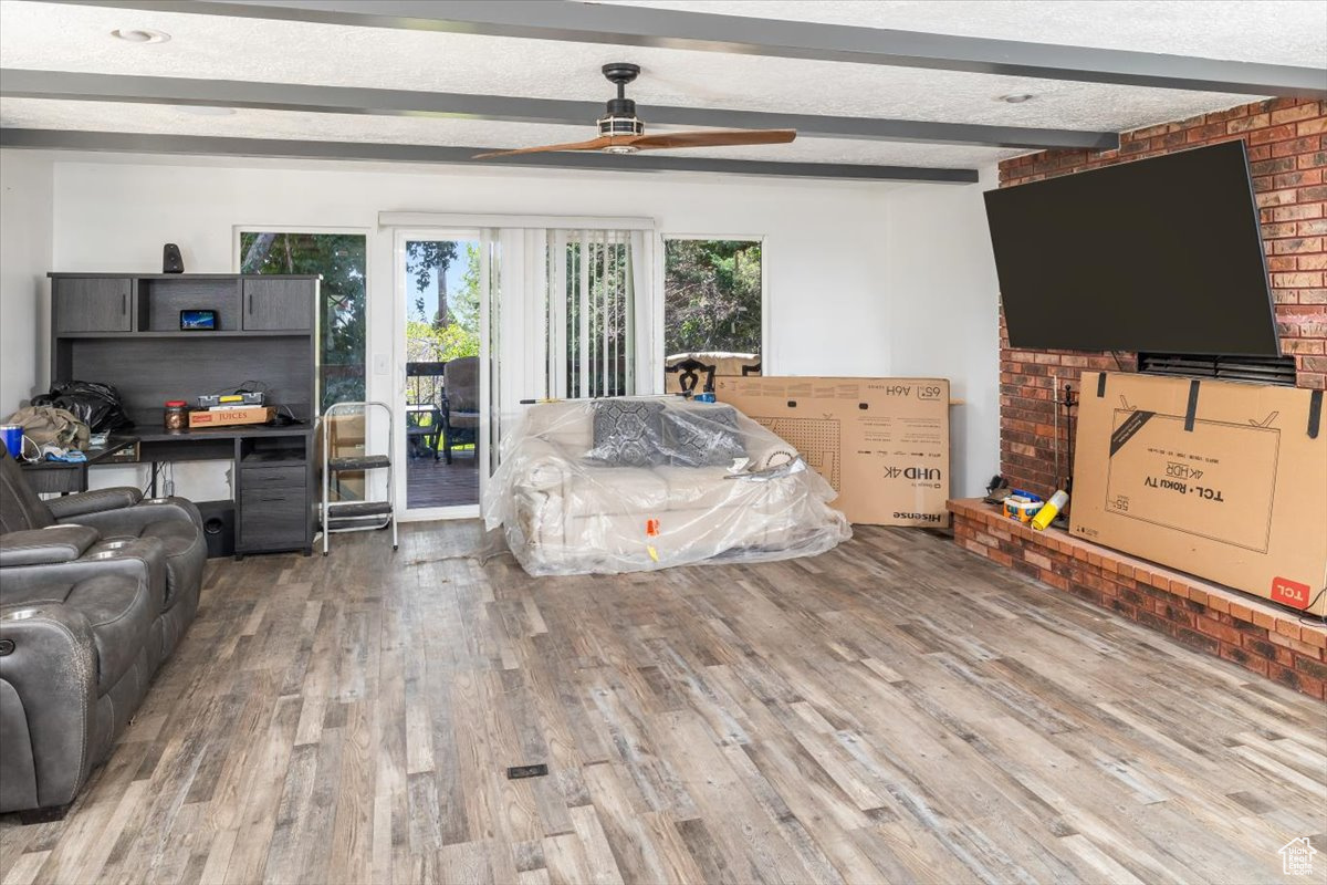 Bedroom with access to outside, ceiling fan, beamed ceiling, and hardwood / wood-style floors