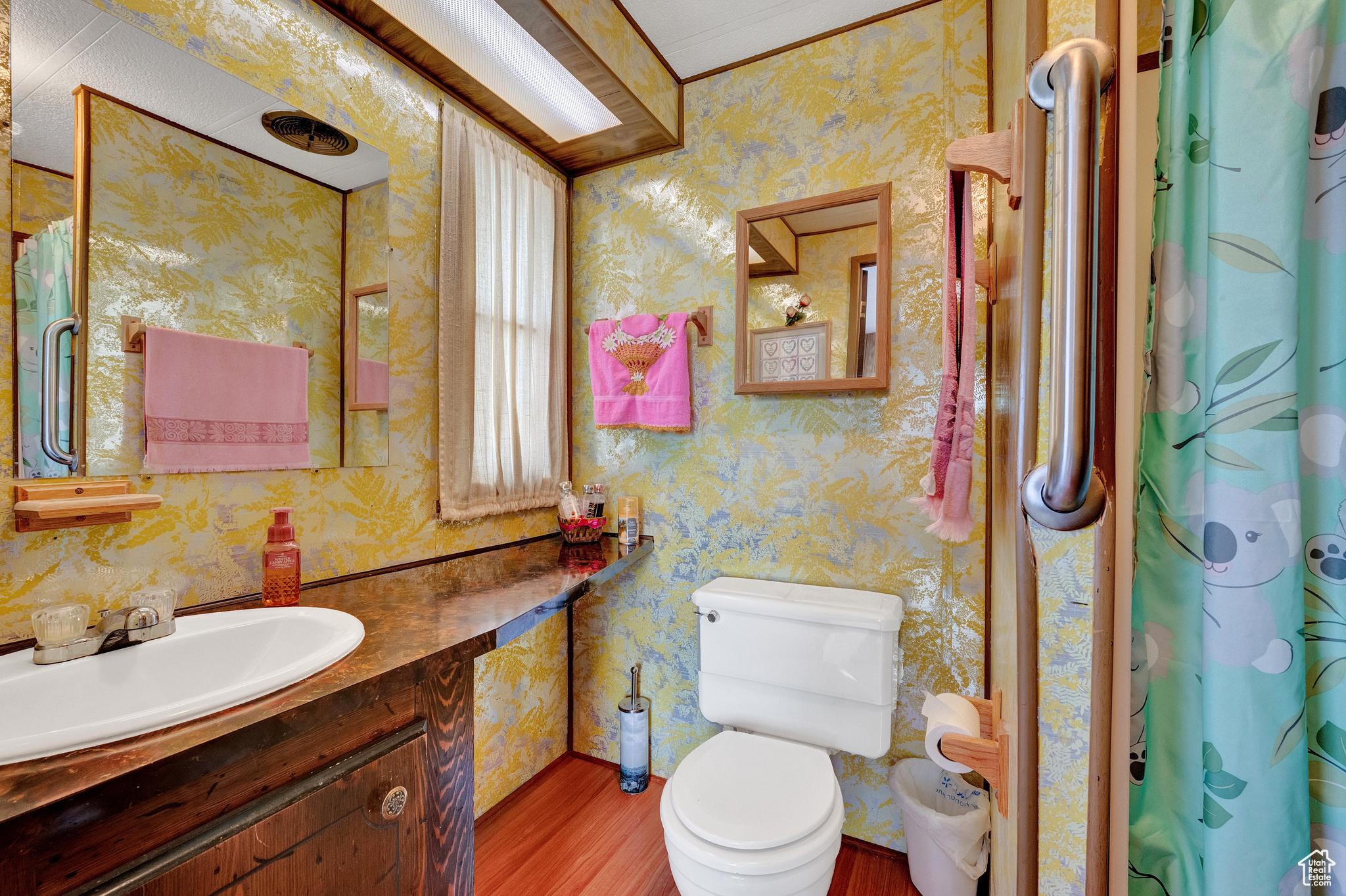 Bathroom featuring a textured ceiling, toilet, hardwood / wood-style floors, and large vanity