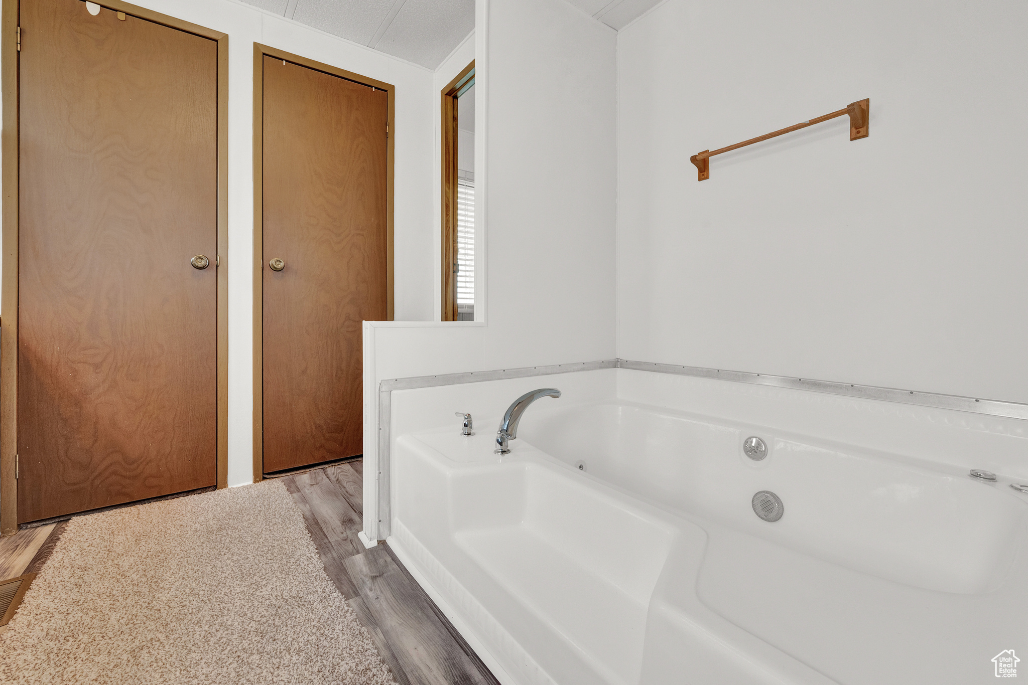 Bathroom with a bath and hardwood / wood-style flooring
