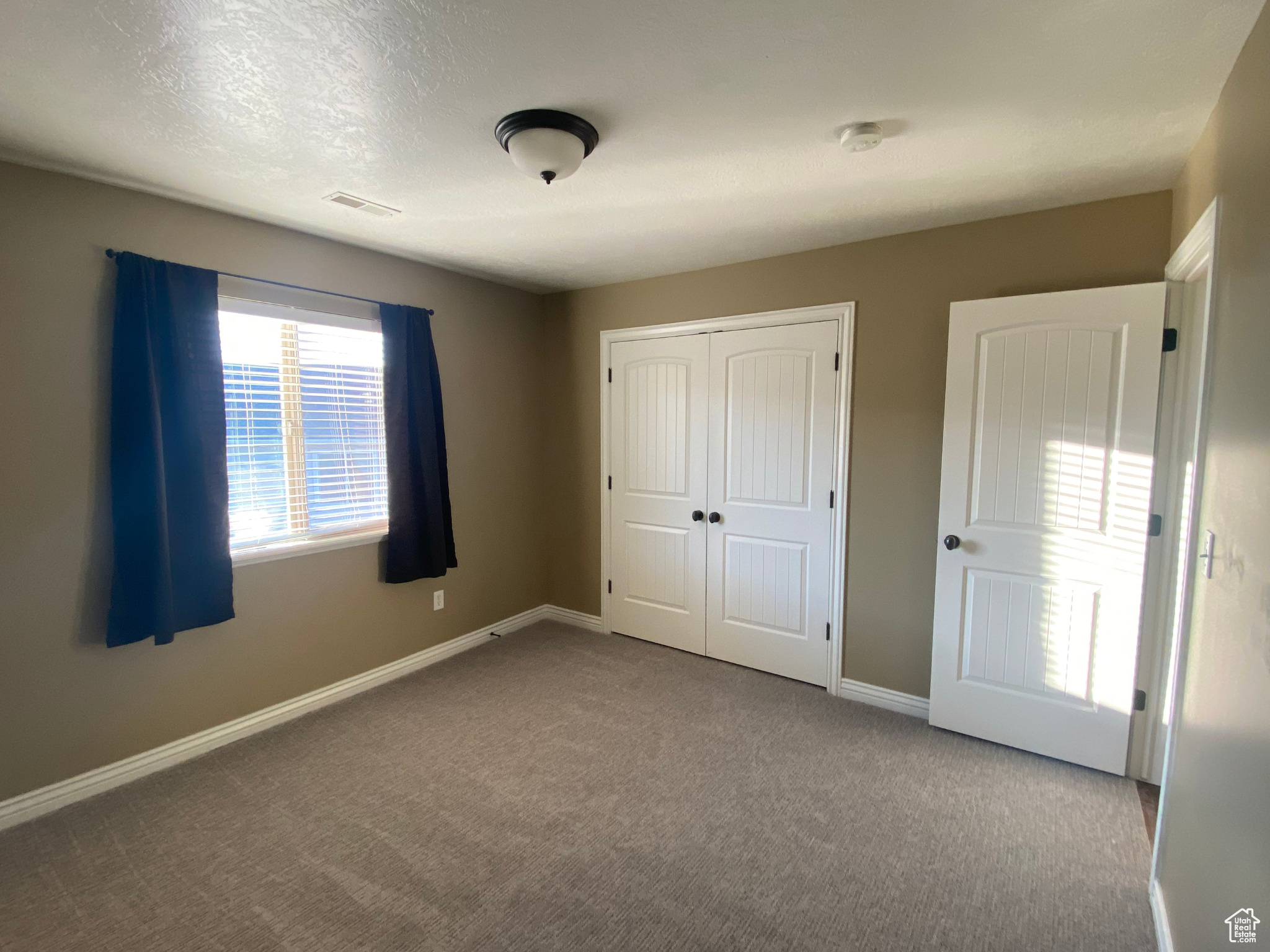 Unfurnished bedroom  with spacious closet and carpet