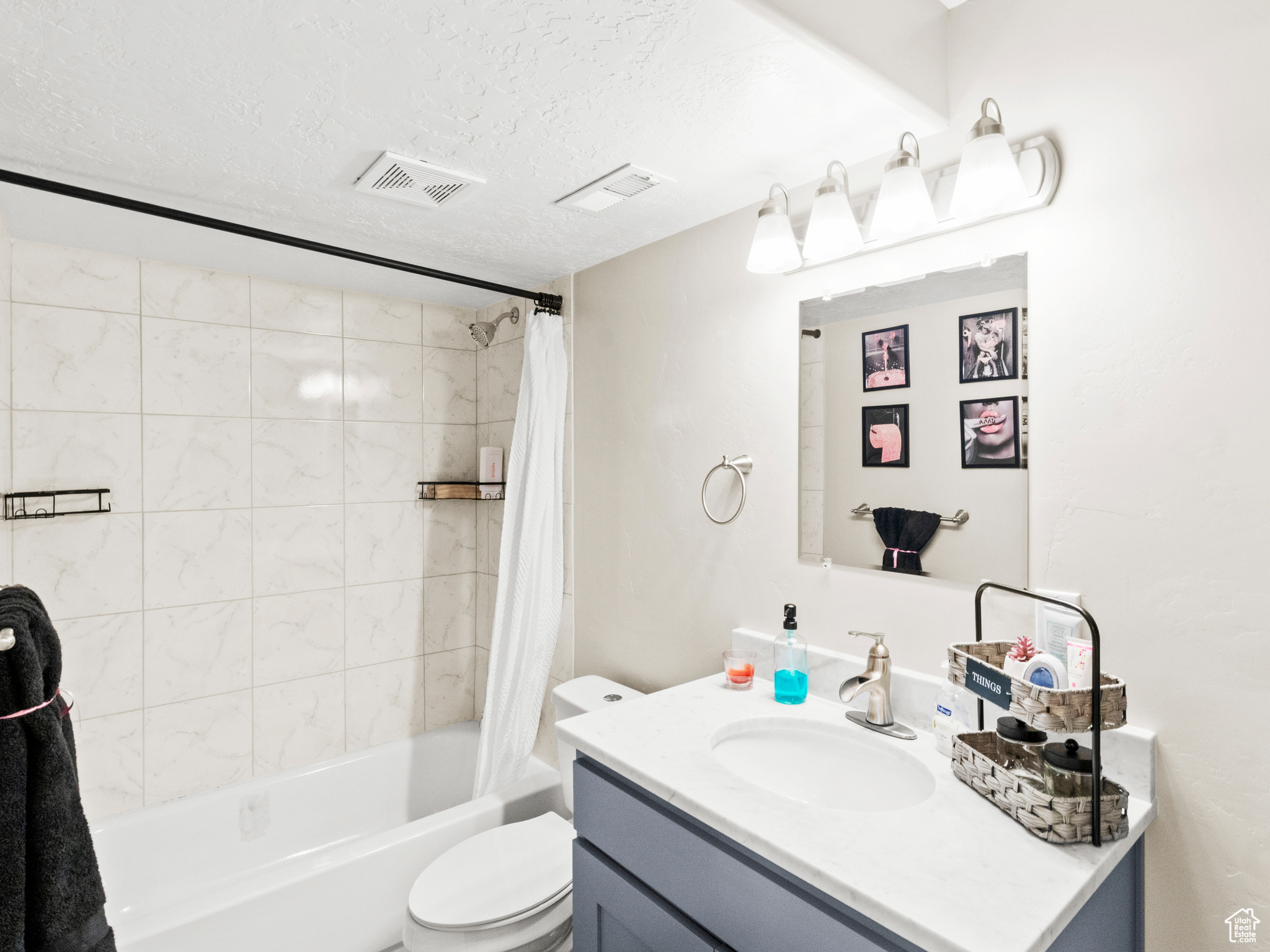 Full bathroom with shower / tub combo, toilet, a textured ceiling, and large vanity