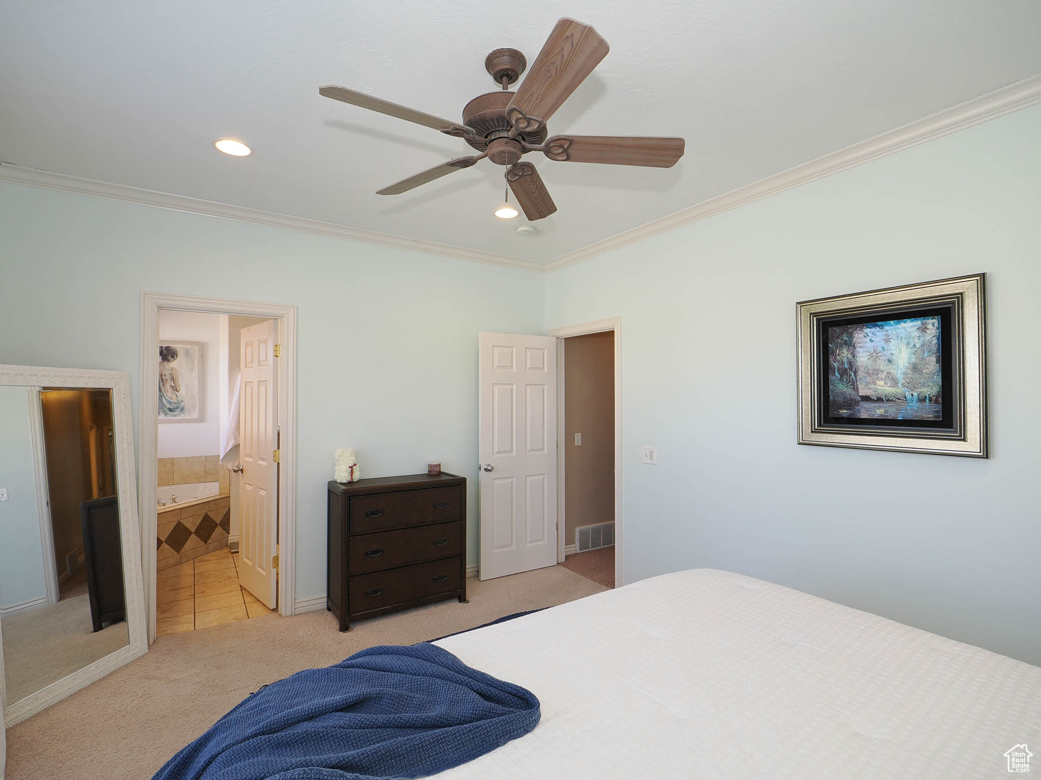 Master bedroom featuring ceiling fan, crown molding, and ensuite bathroom and large walk-in closet
