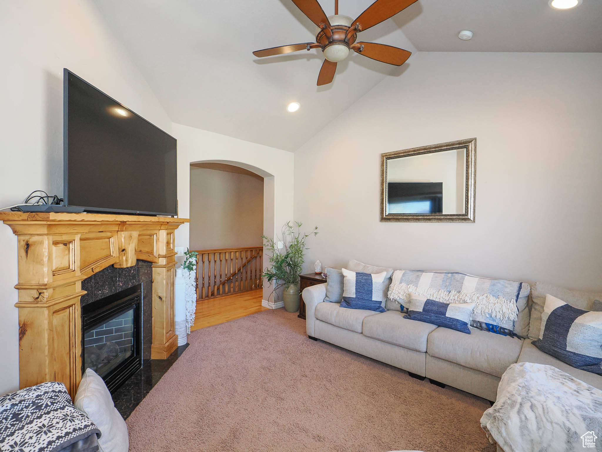 Carpeted family room with lofted ceiling, ceiling fan, and a premium gas fireplace