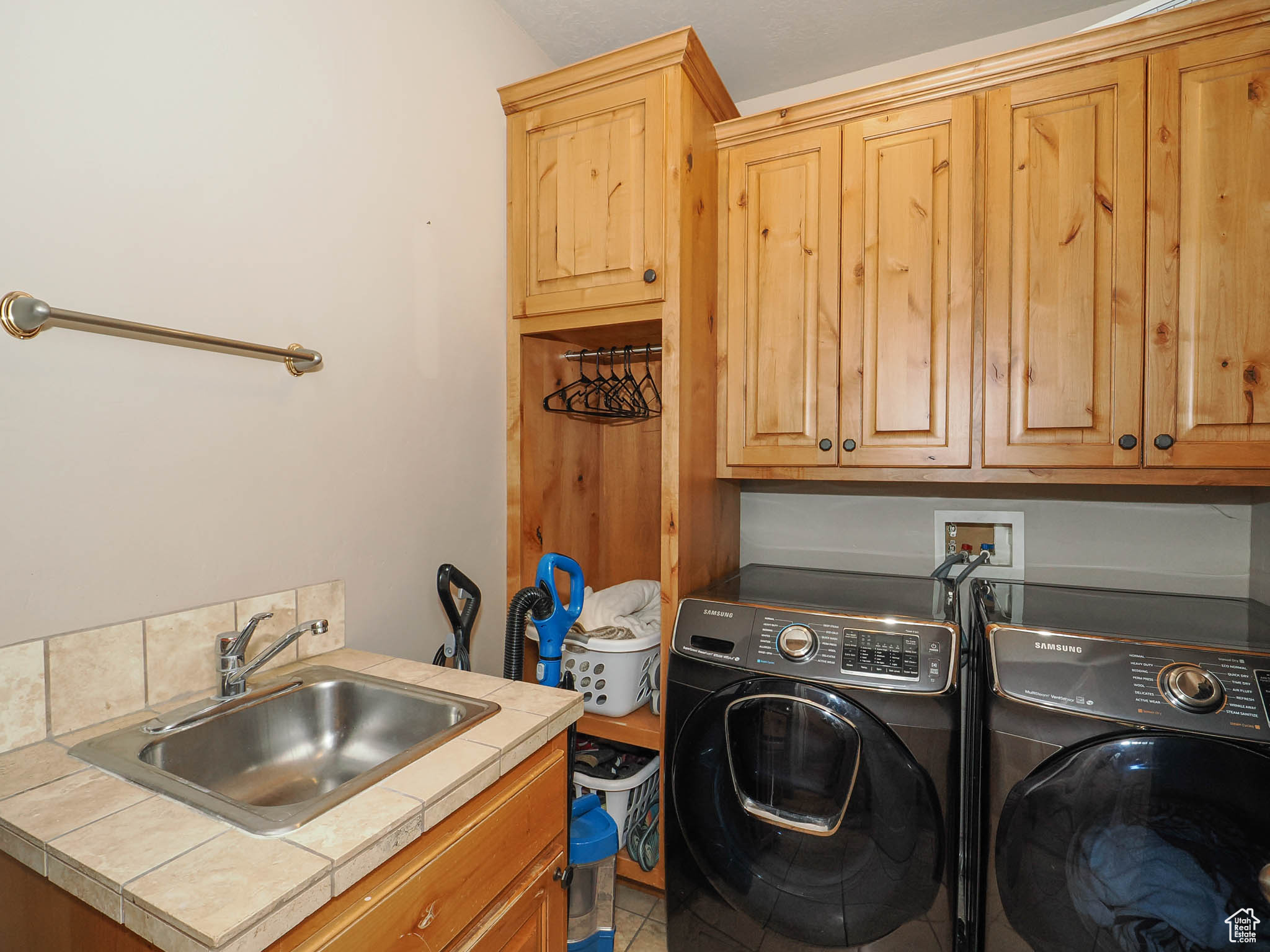Laundry area featuring cabinets, independent washer and dryer, sink, and tile floors