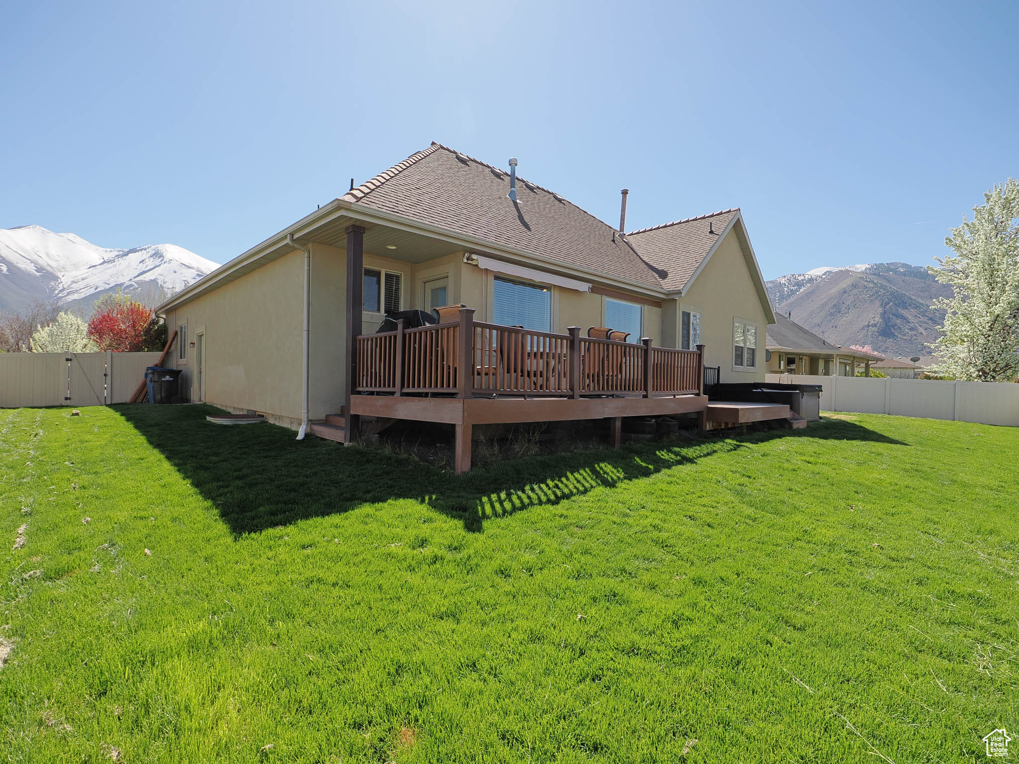 Rear view of house with a lawn and trex deck with mountain view