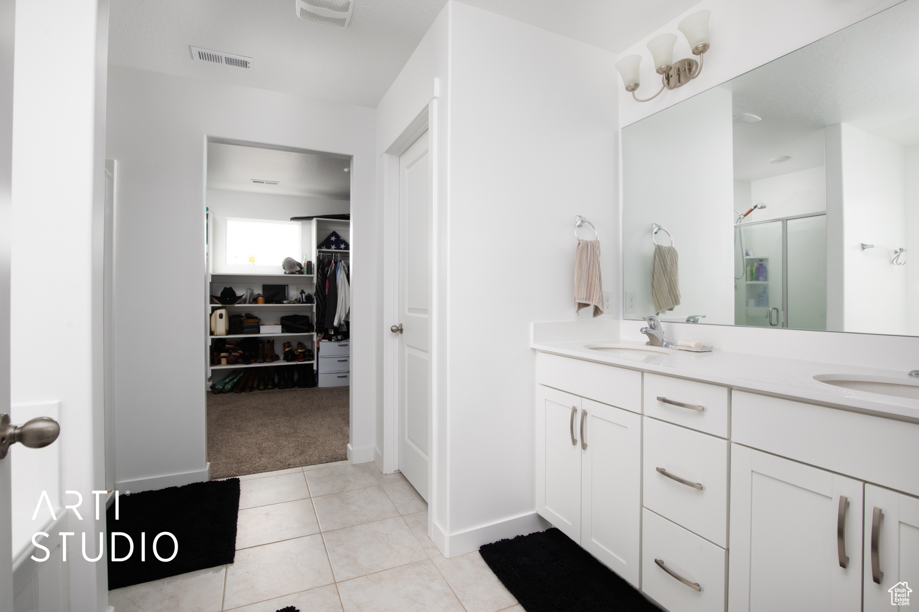 Bathroom featuring tile floors and dual vanity