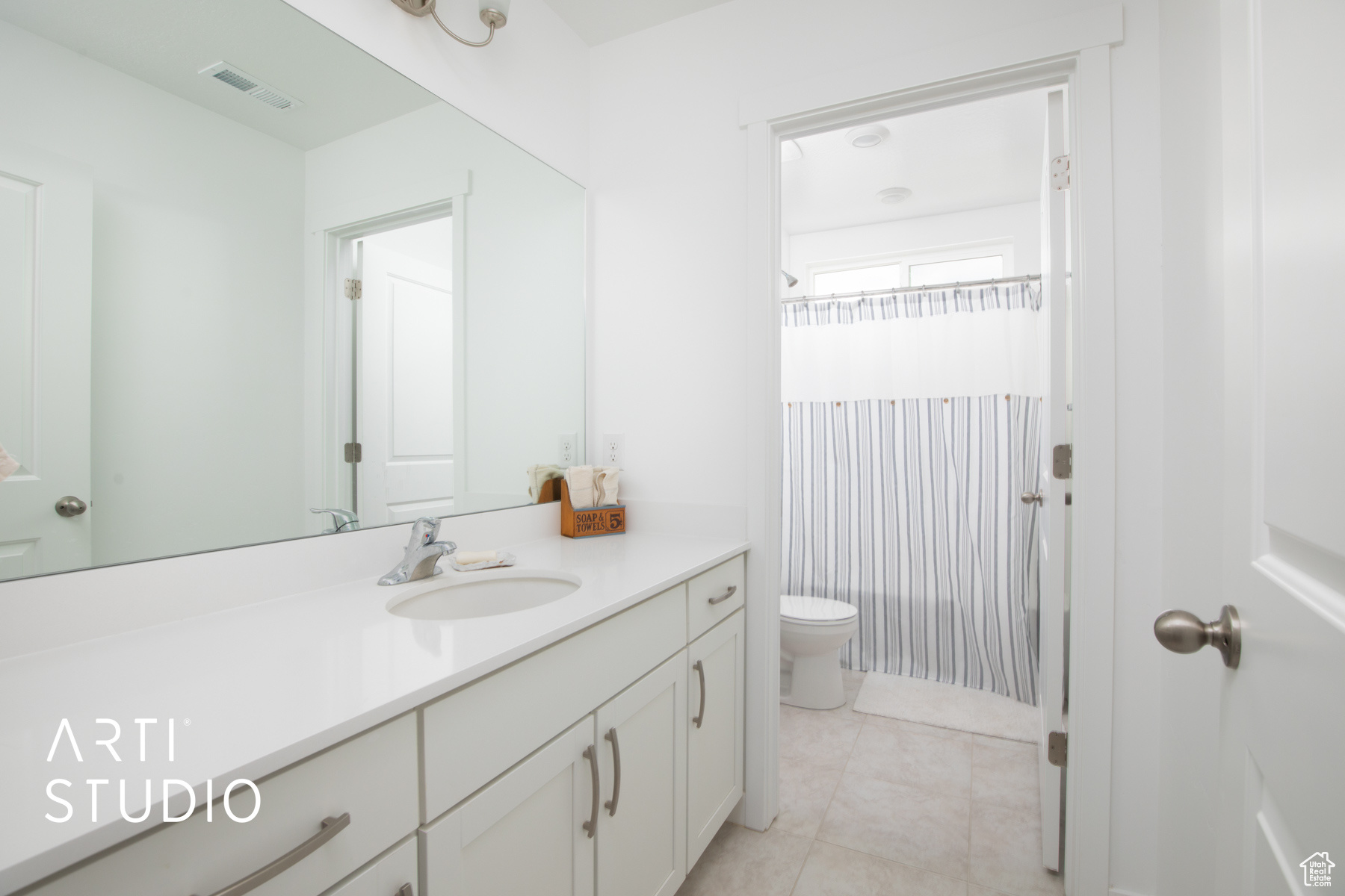 Bathroom featuring vanity, toilet, and tile flooring