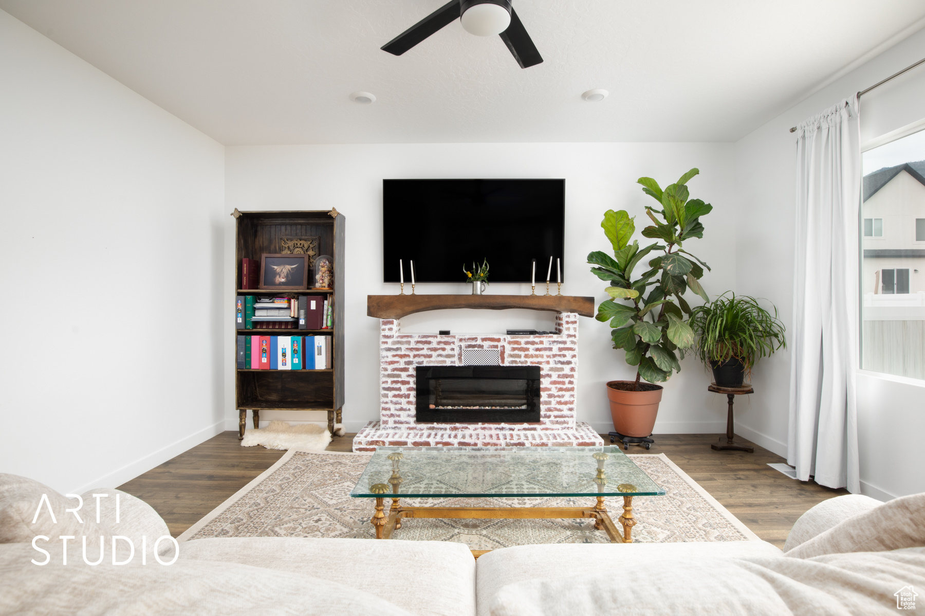 Living room featuring ceiling fan, hardwood / wood-style floors, and a fireplace