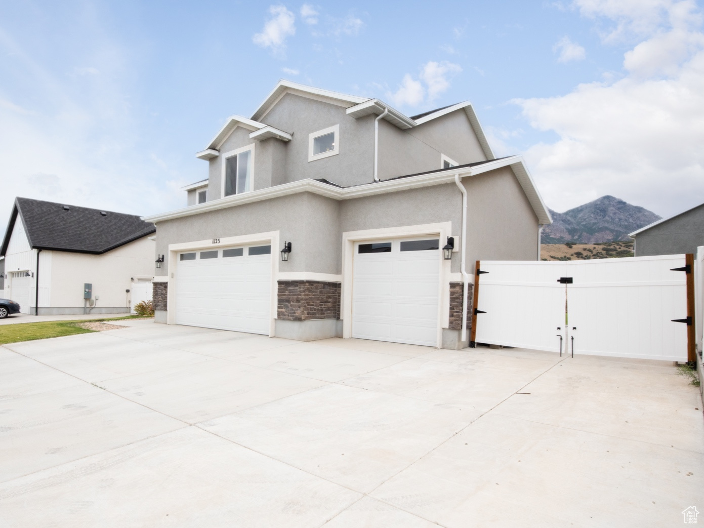 View of side of home with a mountain view and a garage