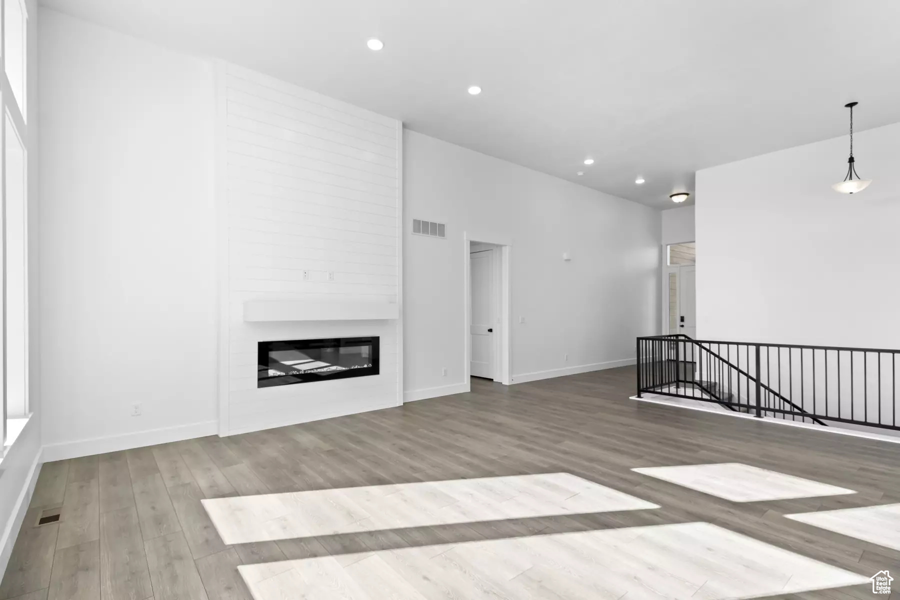 Unfurnished living room featuring a large fireplace and hardwood / wood-style flooring