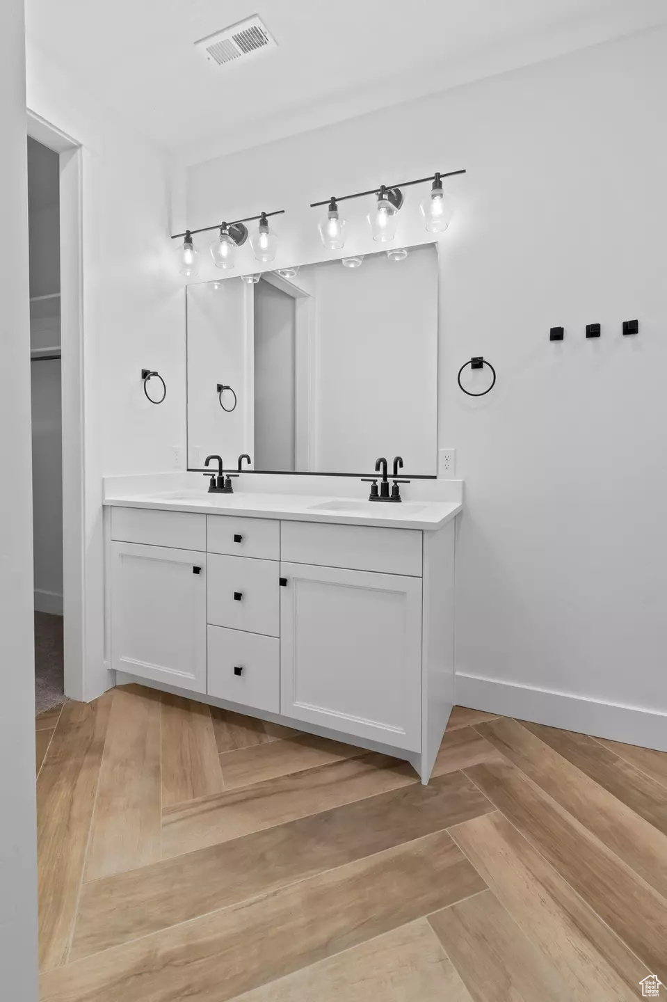 Bathroom featuring dual vanity and parquet floors