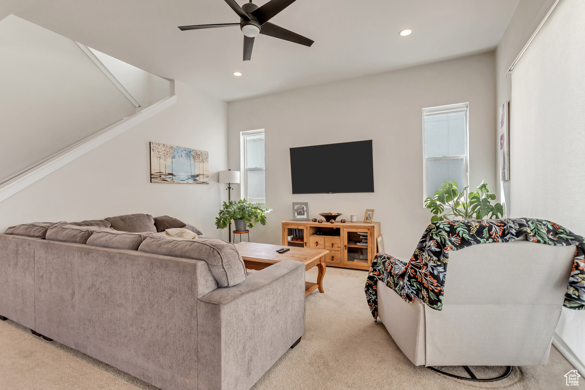 Living room featuring ceiling fan, carpet, and plenty of natural light