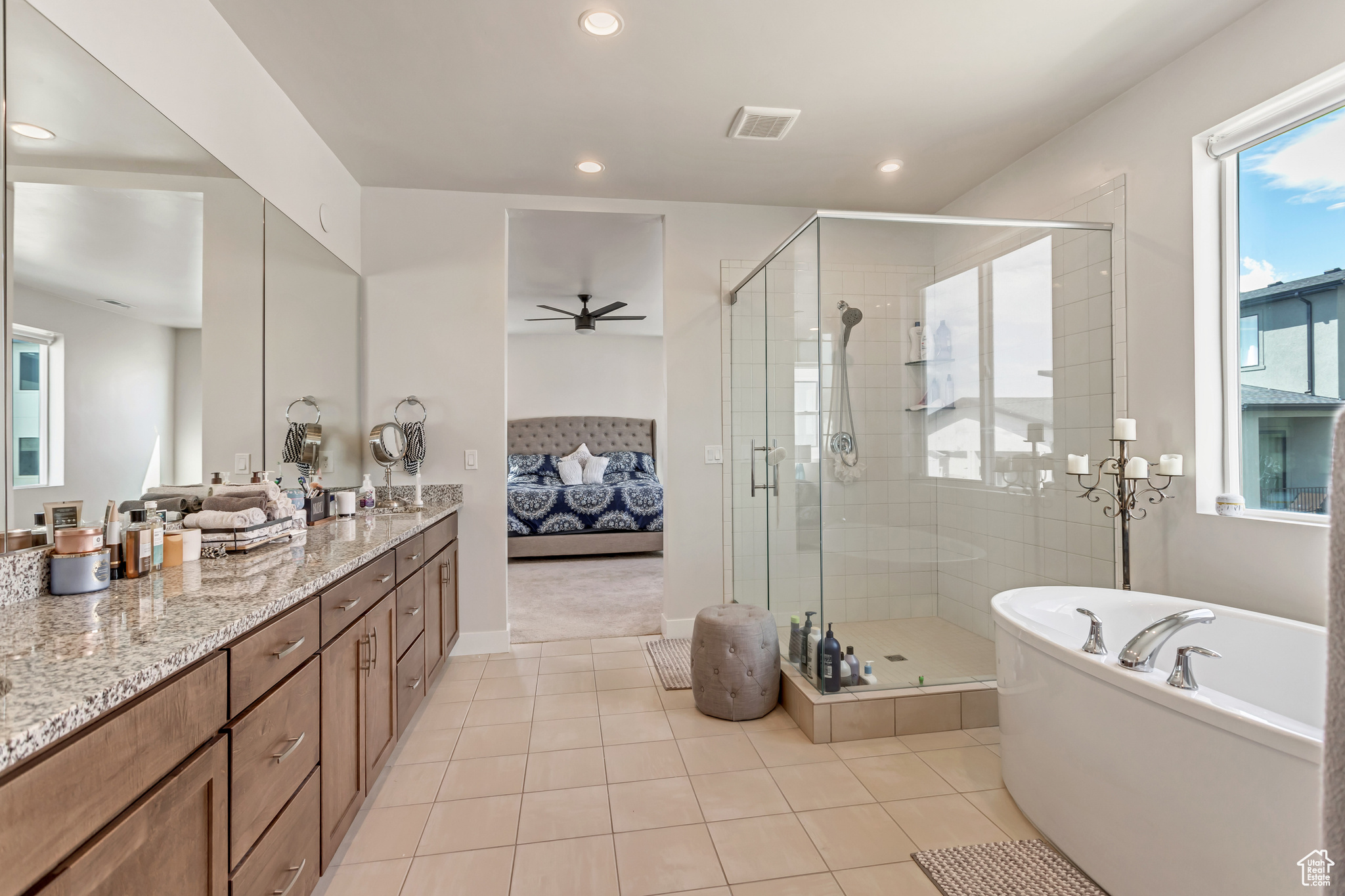 Bathroom featuring ceiling fan, vanity, tile floors, and separate shower and tub