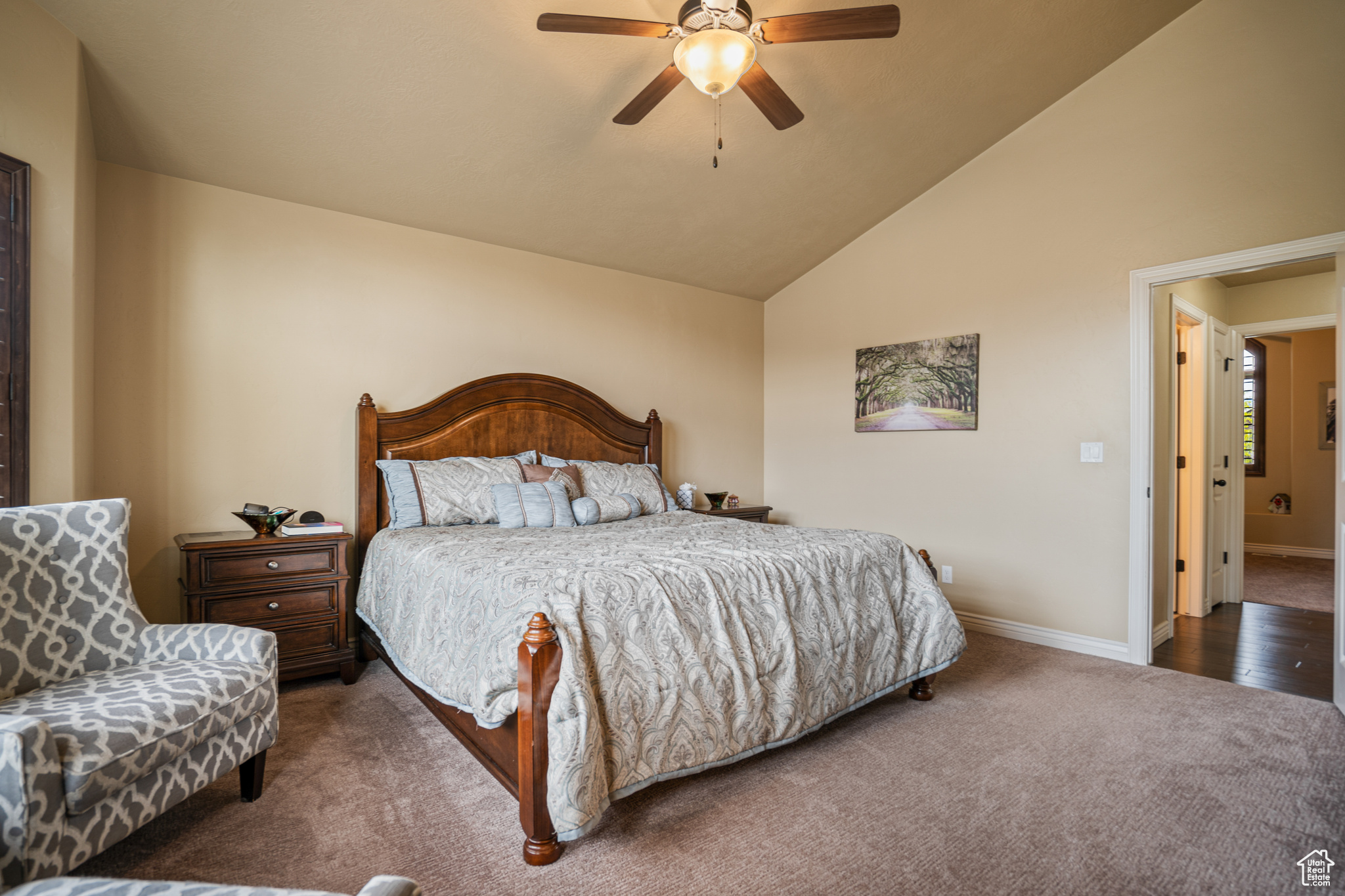 Bedroom featuring ceiling fan, high vaulted ceiling, and dark carpet