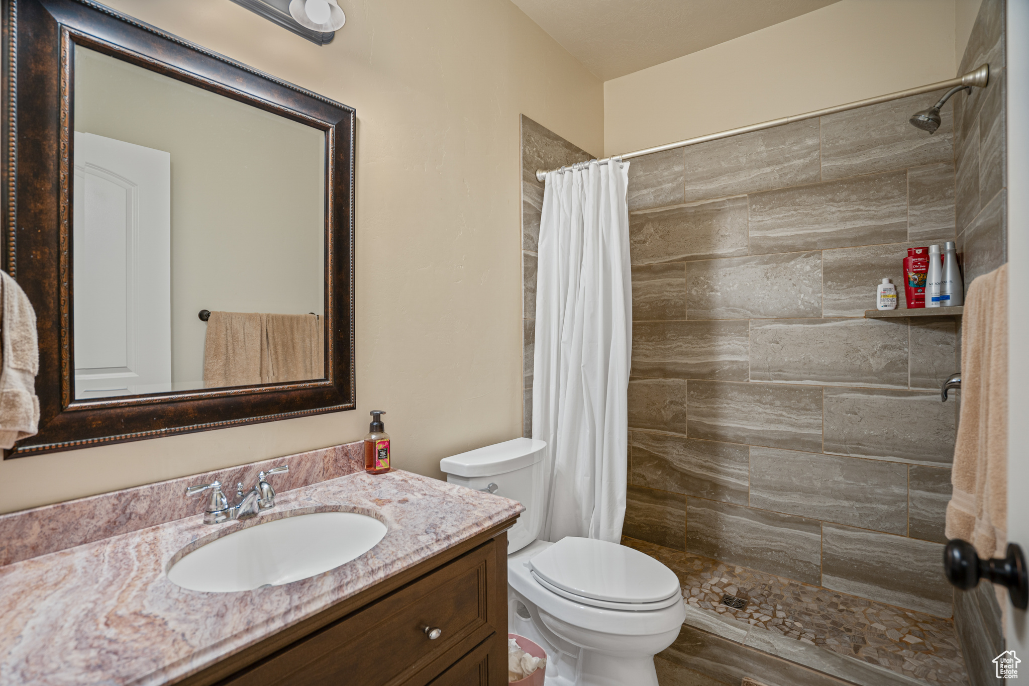 Bathroom featuring hardwood / wood-style floors, walk in shower, vanity, and toilet
